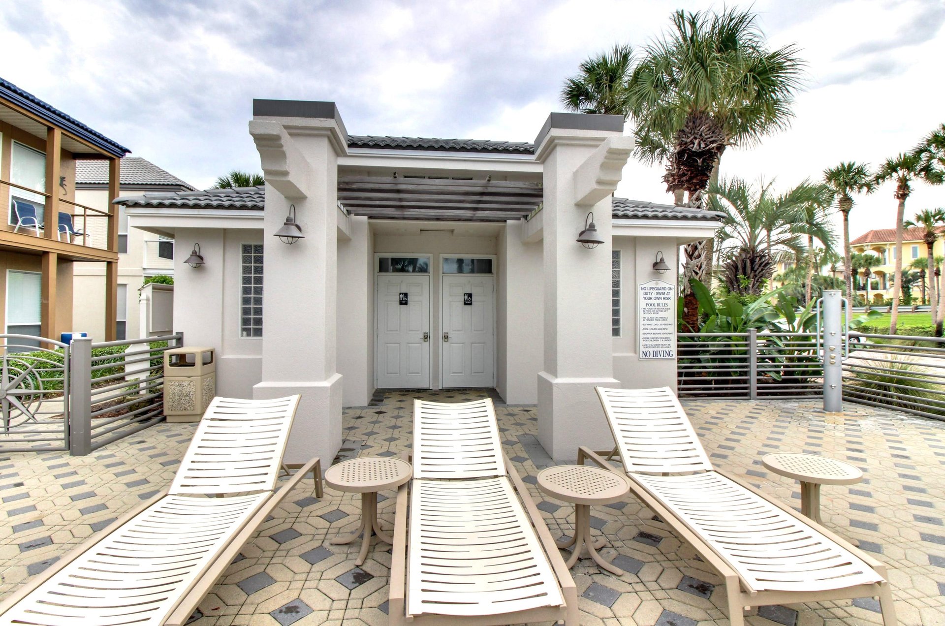 The community pool area is equipped with comfortable loungers and poolside bathrooms.