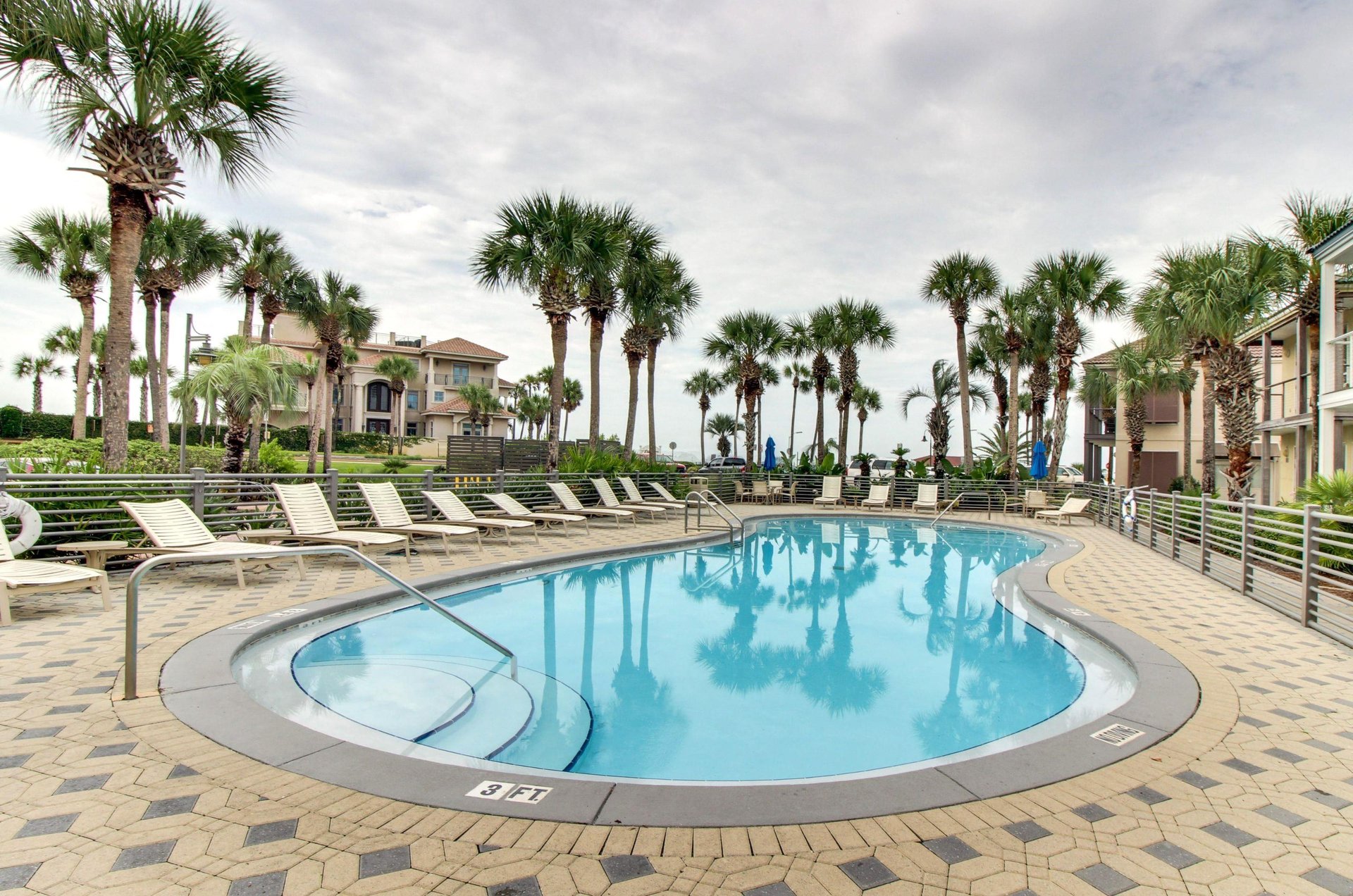 The community pools sundeck is set up with dozens of lounge chairs.