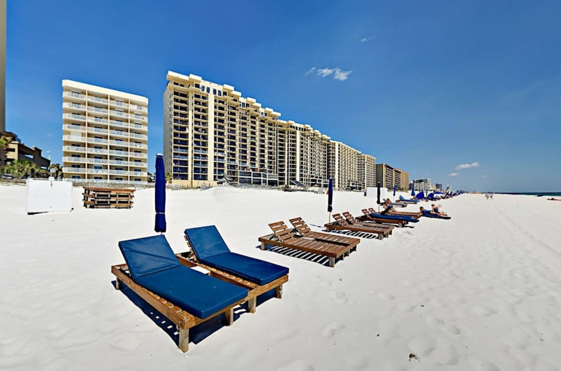 Beach chairs and umbrellas on the beach in front of Four Winds in Orange Beach Alabama