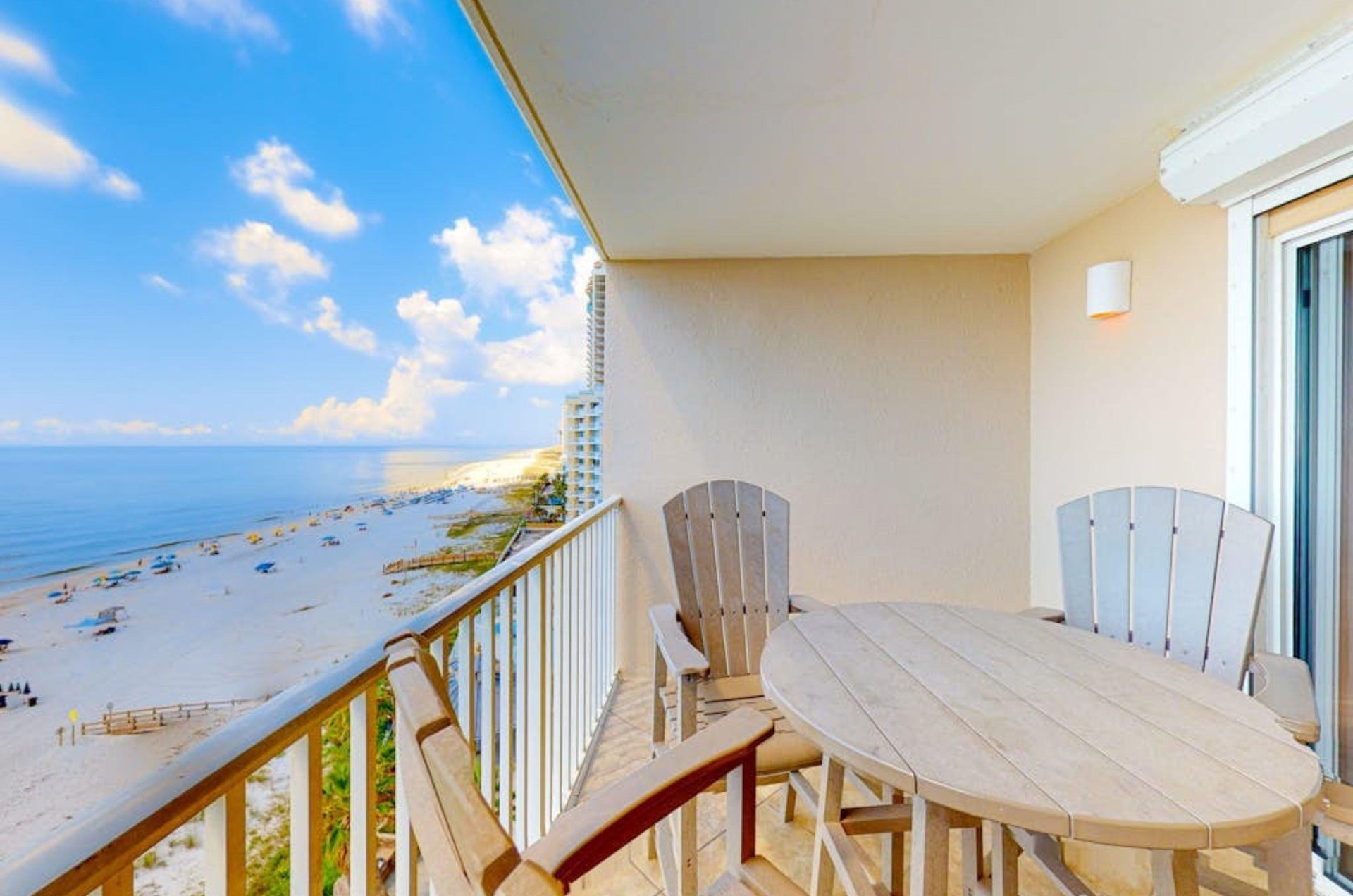 A private balcony with dining chairs and tables overlooking the Gulf