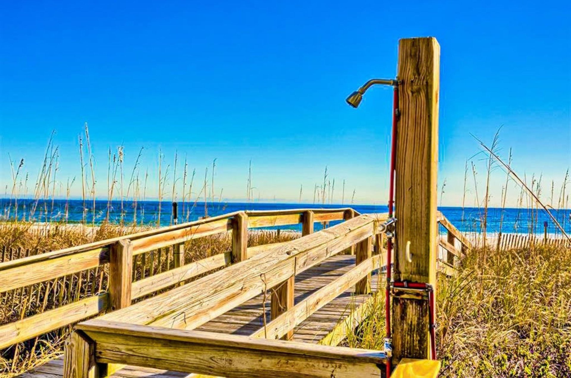 The outdoor shower next to the wooden boardwalk at Four Winds in Orange Beach Alabama