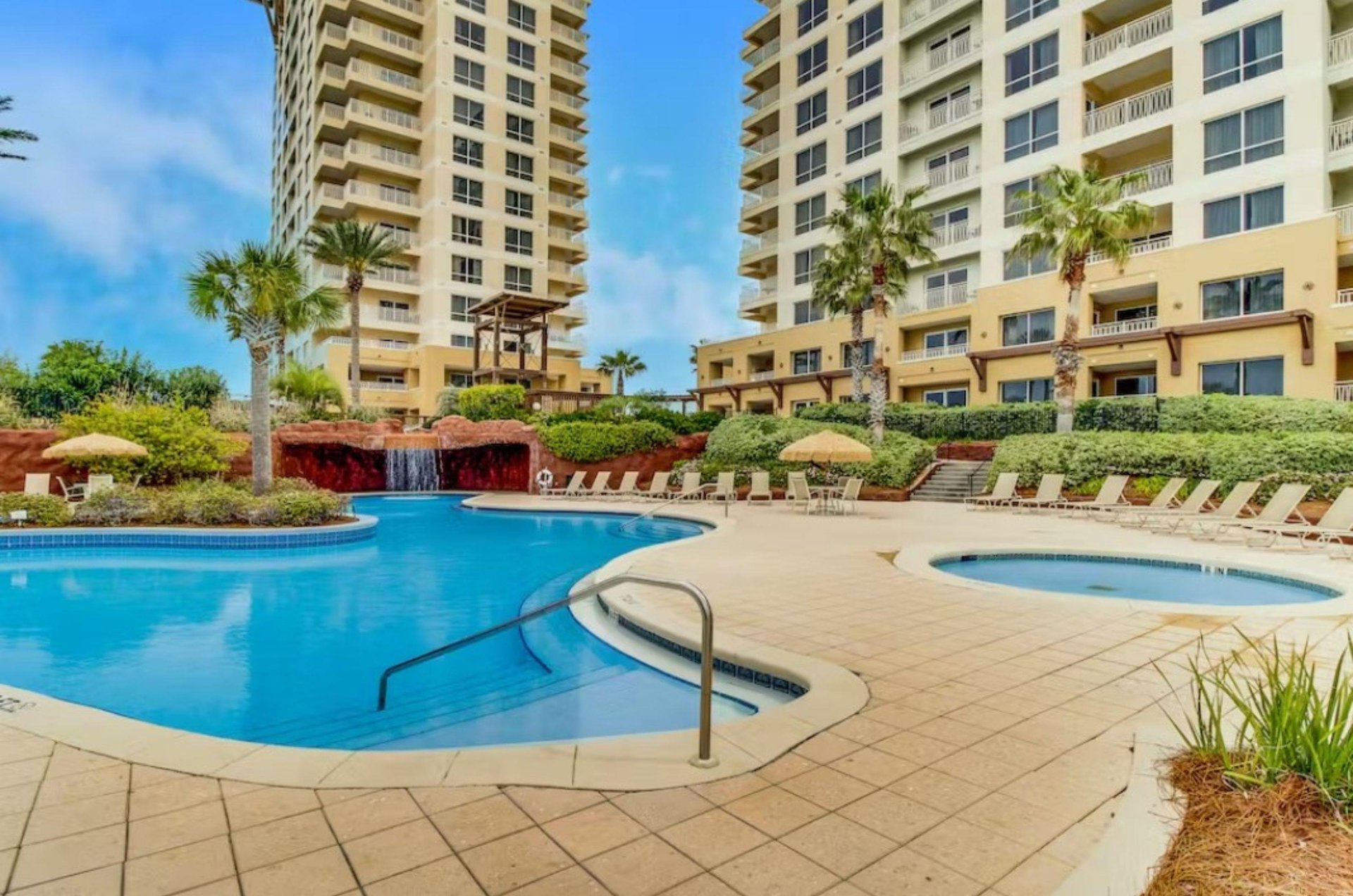 The sparkling aqua lagoon pool leads to a cavelike feature with a waterfall at its entrance