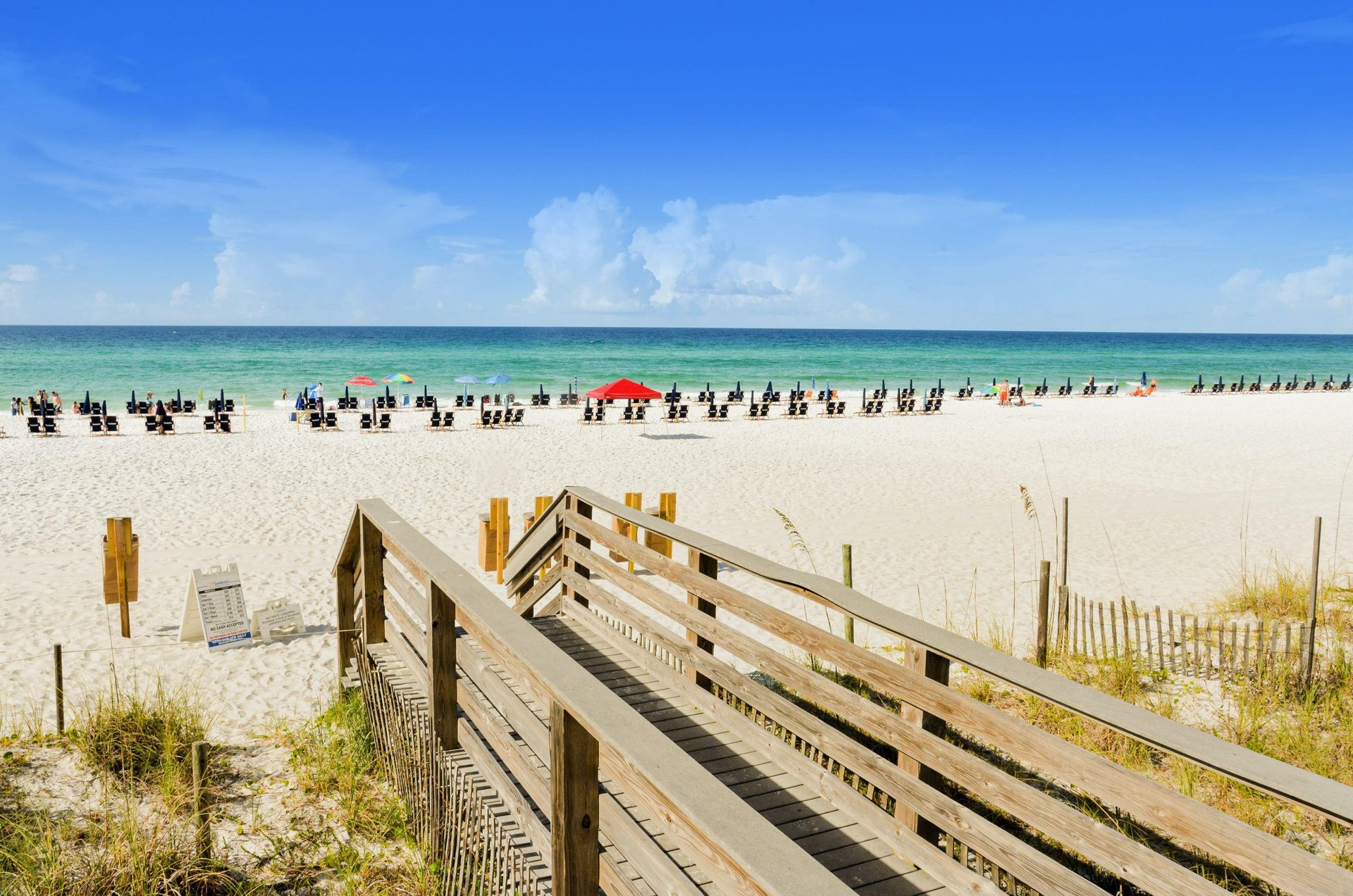 A beach boardwalk leads directly to the white sand beach and turquoise blue Gulf waters near Sandestin Golf and Beach Resorts Luau complex