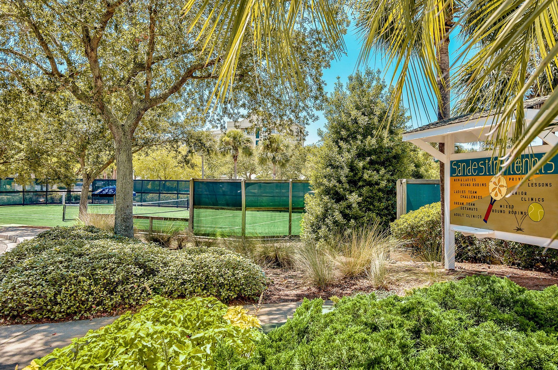 A Luau tennis court sits amid tropical landscaping providing semi shade for players