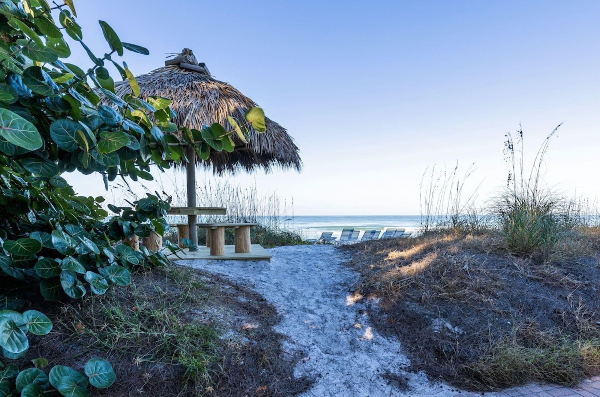 A sandy pathway leading to a hut and the beach at Anna Maria Island Inn in Bradenton Beach Florida