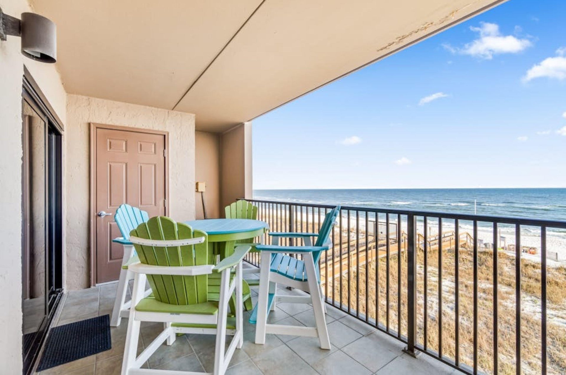 Outdoor dining chairs and table on a private balcony at Ocean Breeze West