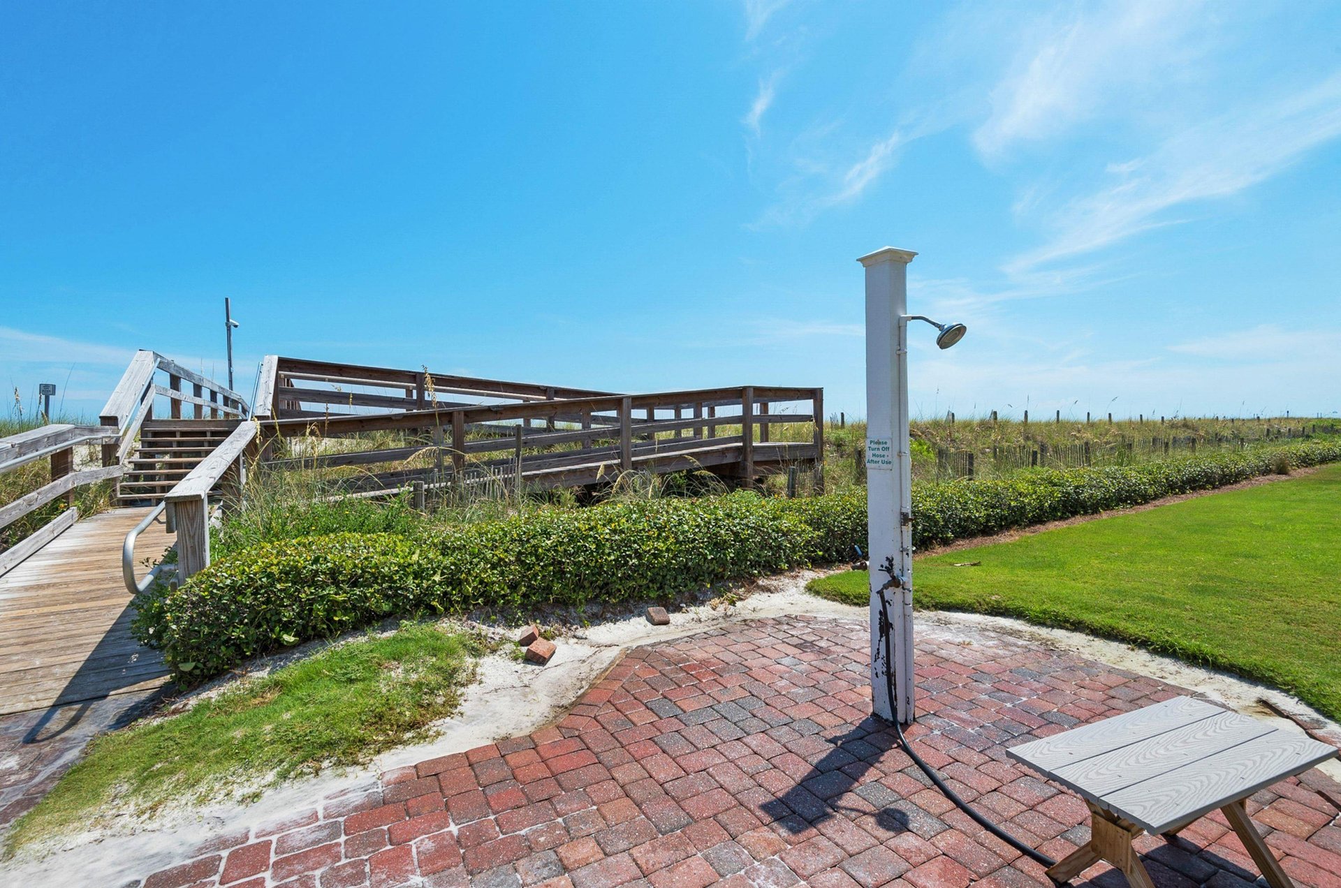 Guests use the shorwer by the beach boardwalk to wash sand and salt off before heading to the swimming pool.