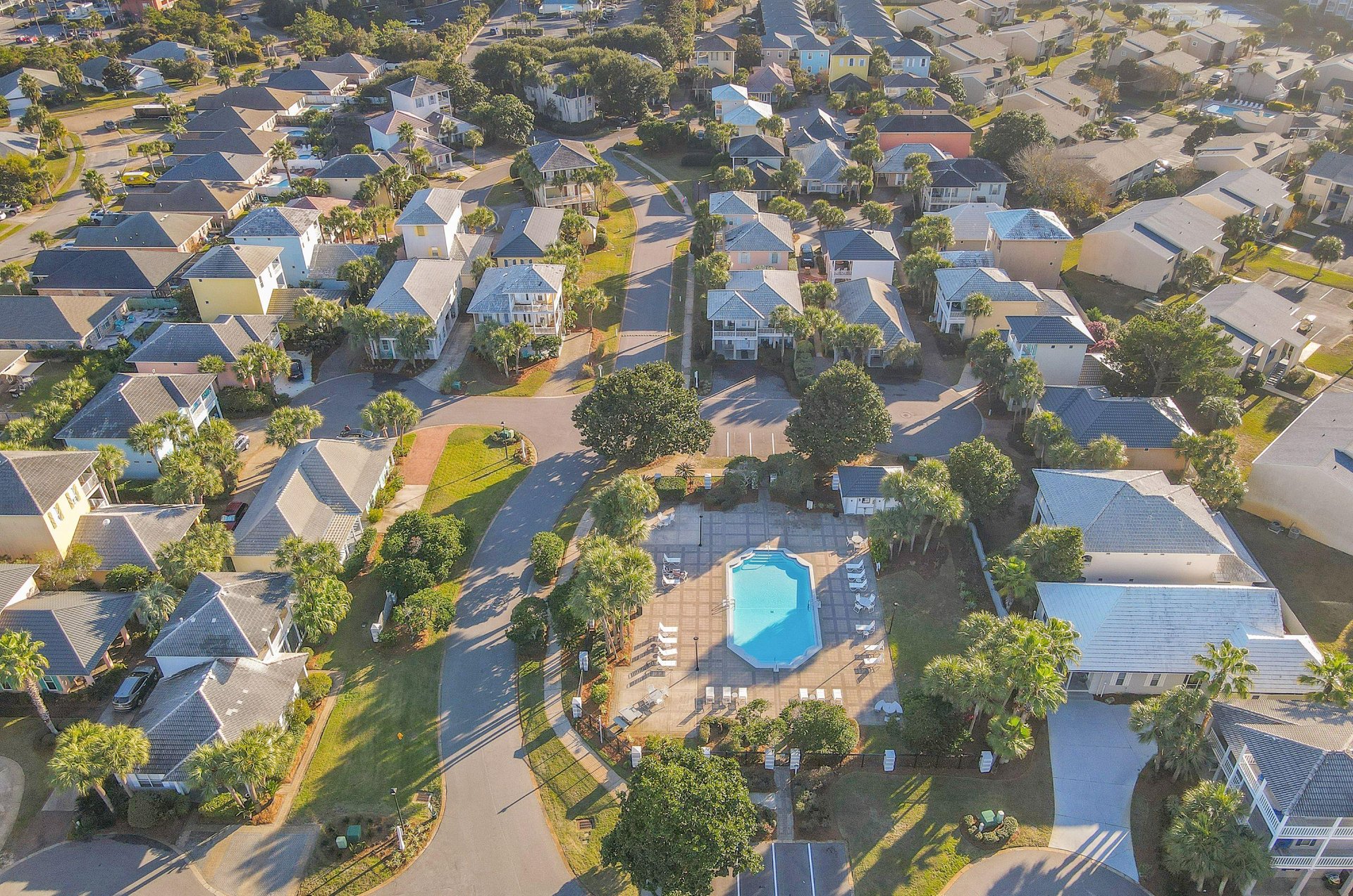 An aerial view of part of the neighborhood, including its beautiful blue swimming pool.