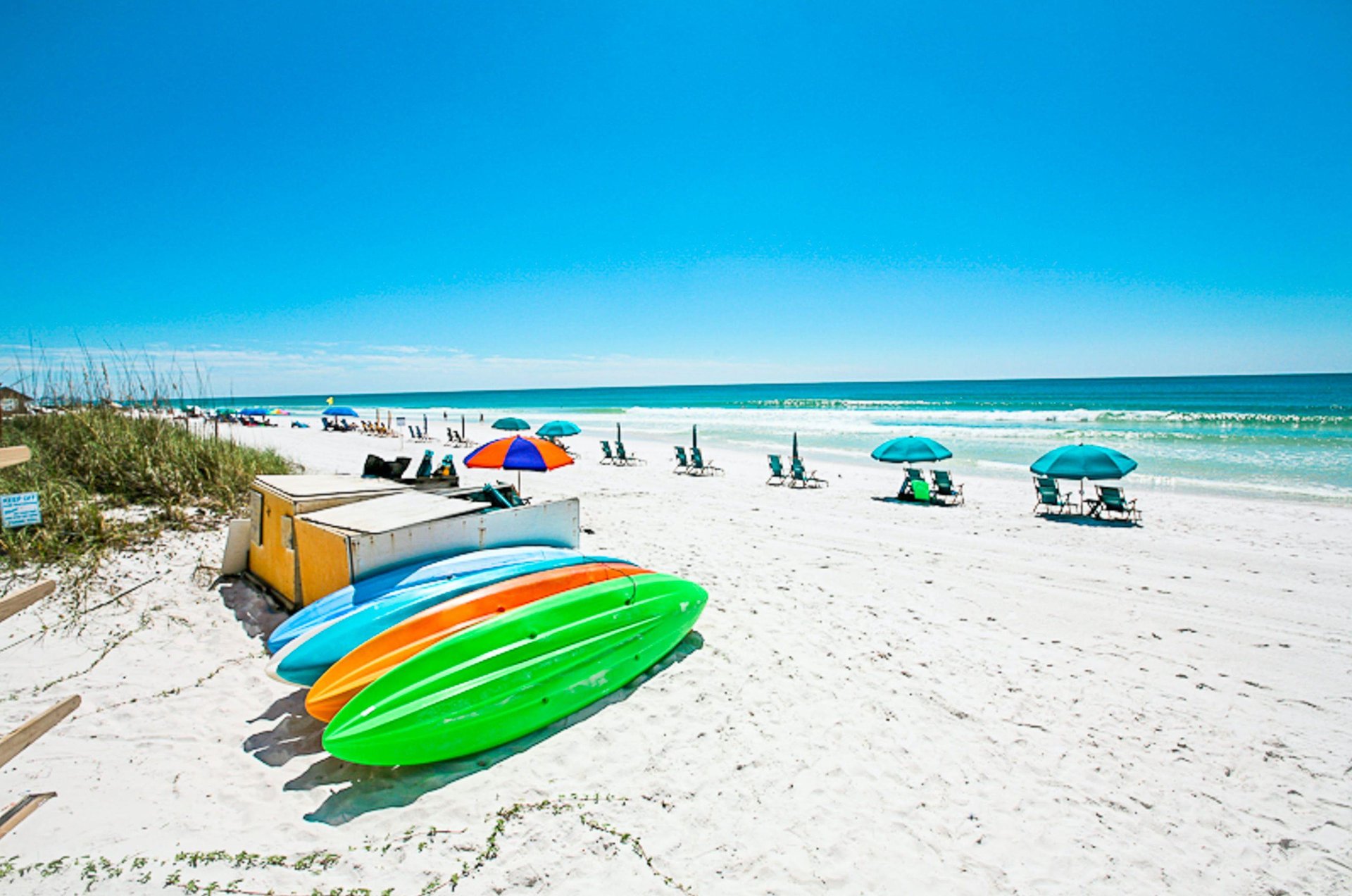 Kayaks and beach chairs with umbrellas ready for use