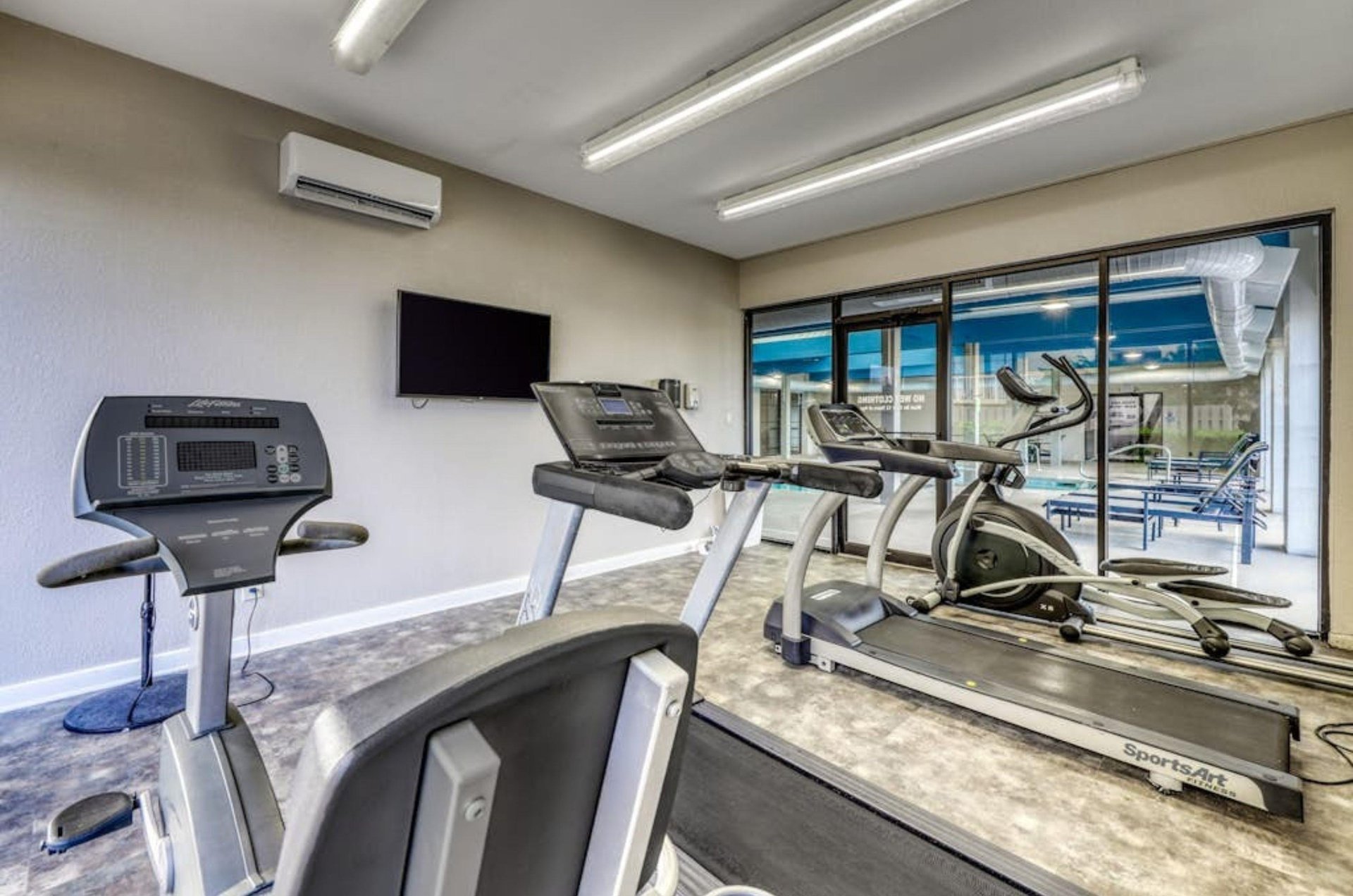 Cardio equpiment and a television in the onsite fitness center at Bluewater Condominiums