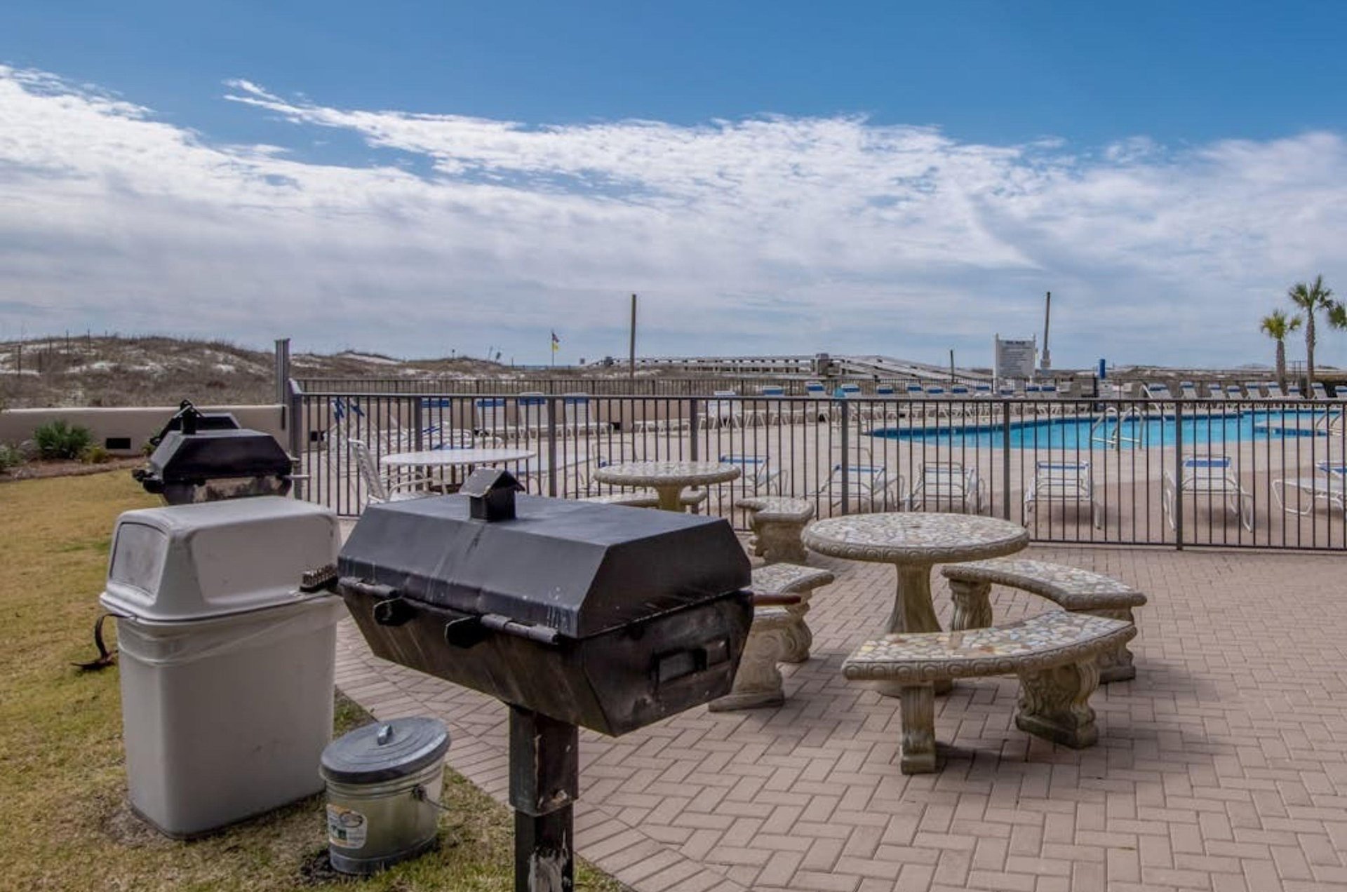 Charcoal grills and a picnic table next to the pool at Phoenix II