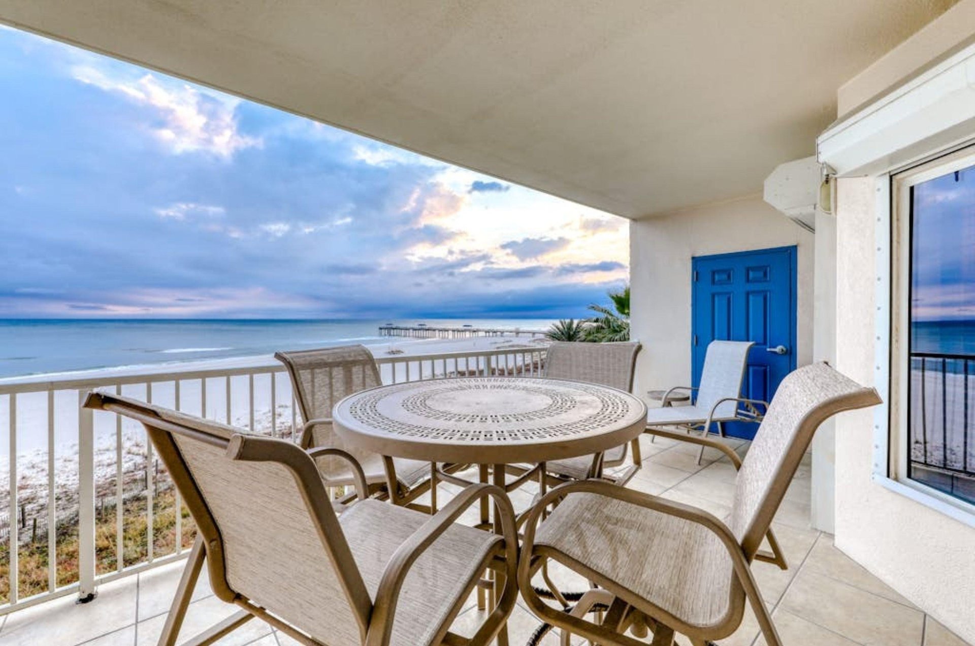 A private balcony overlooking the Gulf with a table and four chairs