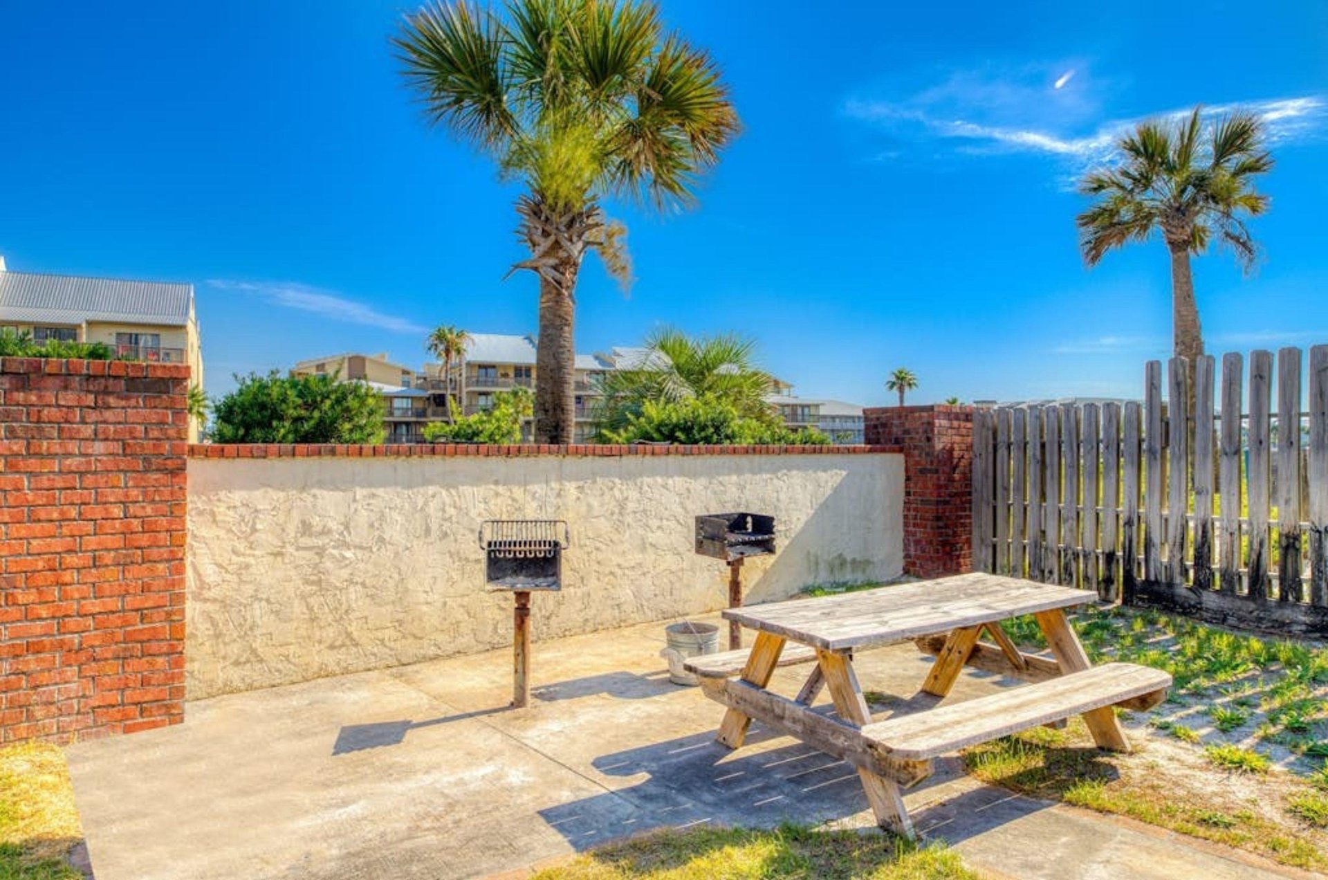Barbecue grills next to a wooden picnic table at Lei Lani in Orange Beach Alabama