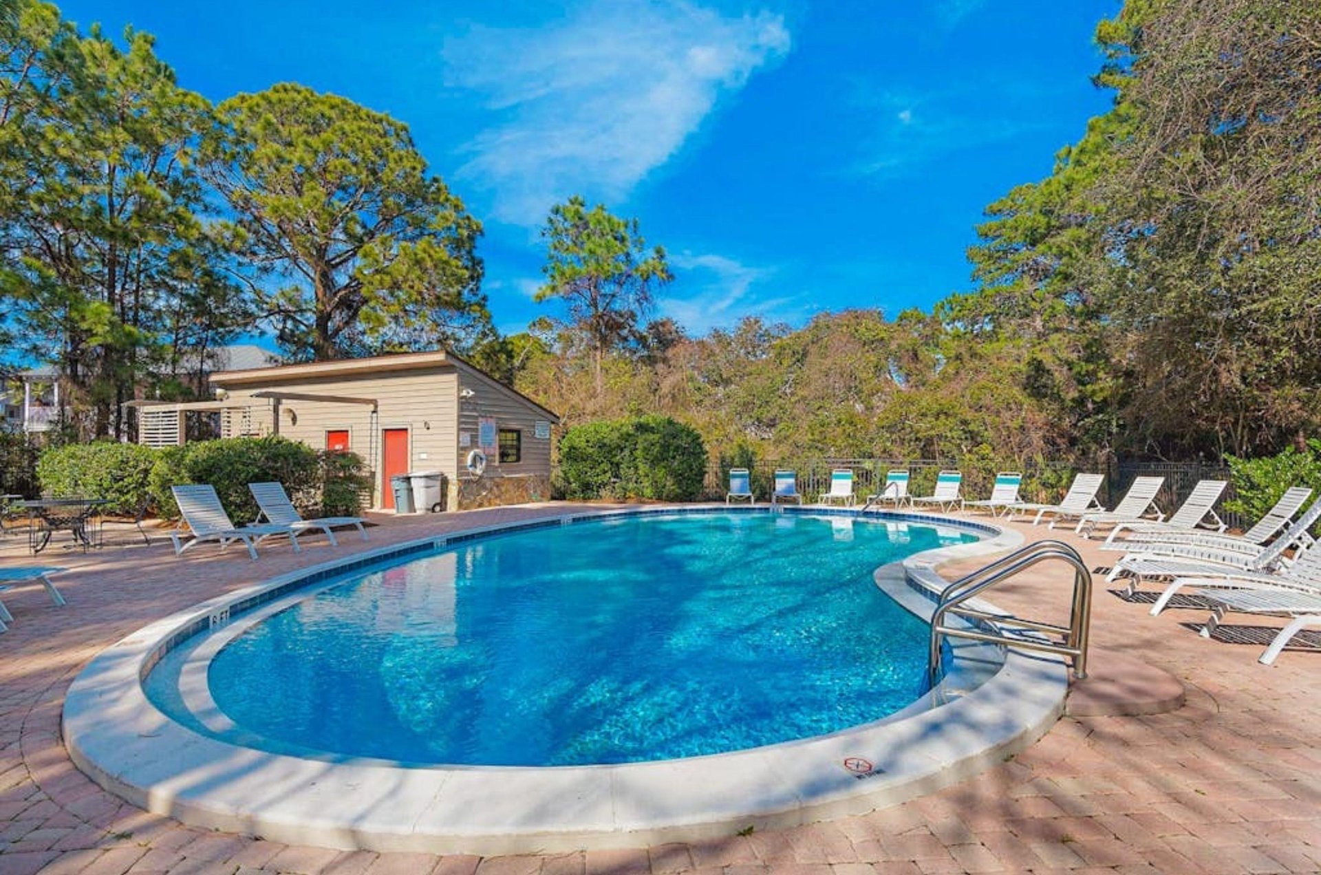 One of the outdoor pools surrounded by trees and lounge chairs at Cassine Station in Seagrove Beach Florida