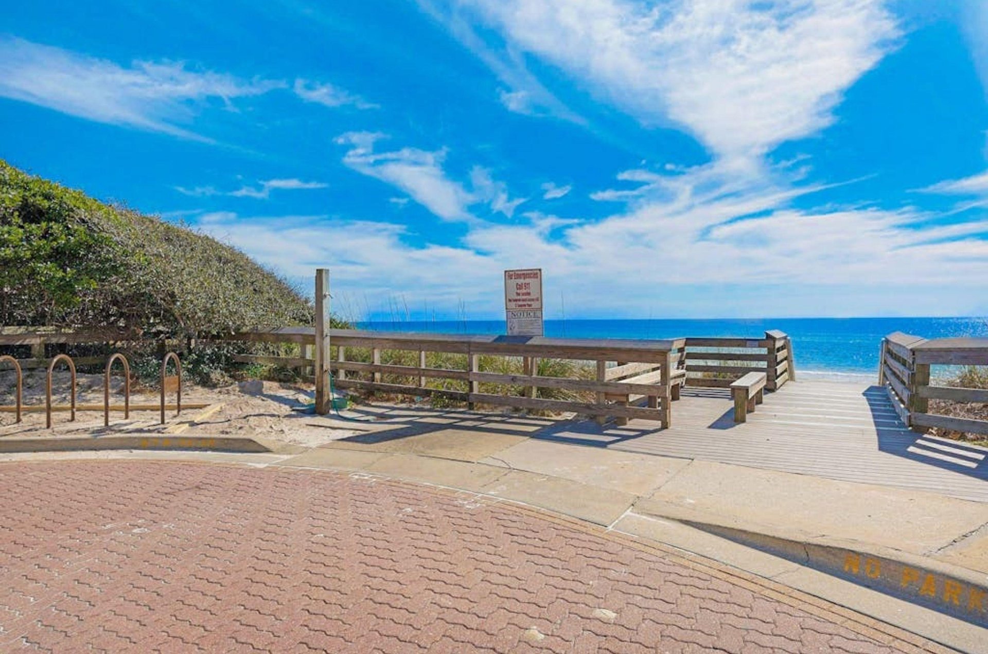 A wooden fence next to the beach with outdoor showers on Highway 30A
