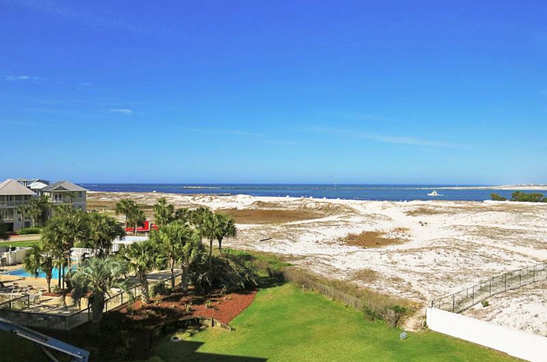 A community pool, with sand dunes and the East Pass beyond
