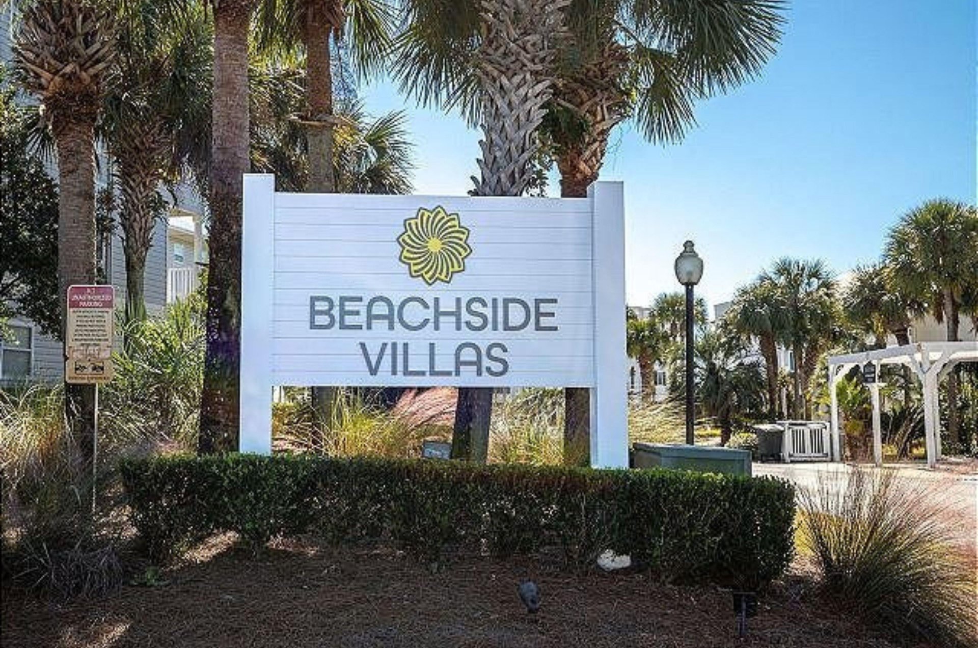 The propertys entry sign with the condos behind it at Beachside Villas in Seagrove Beach Florida