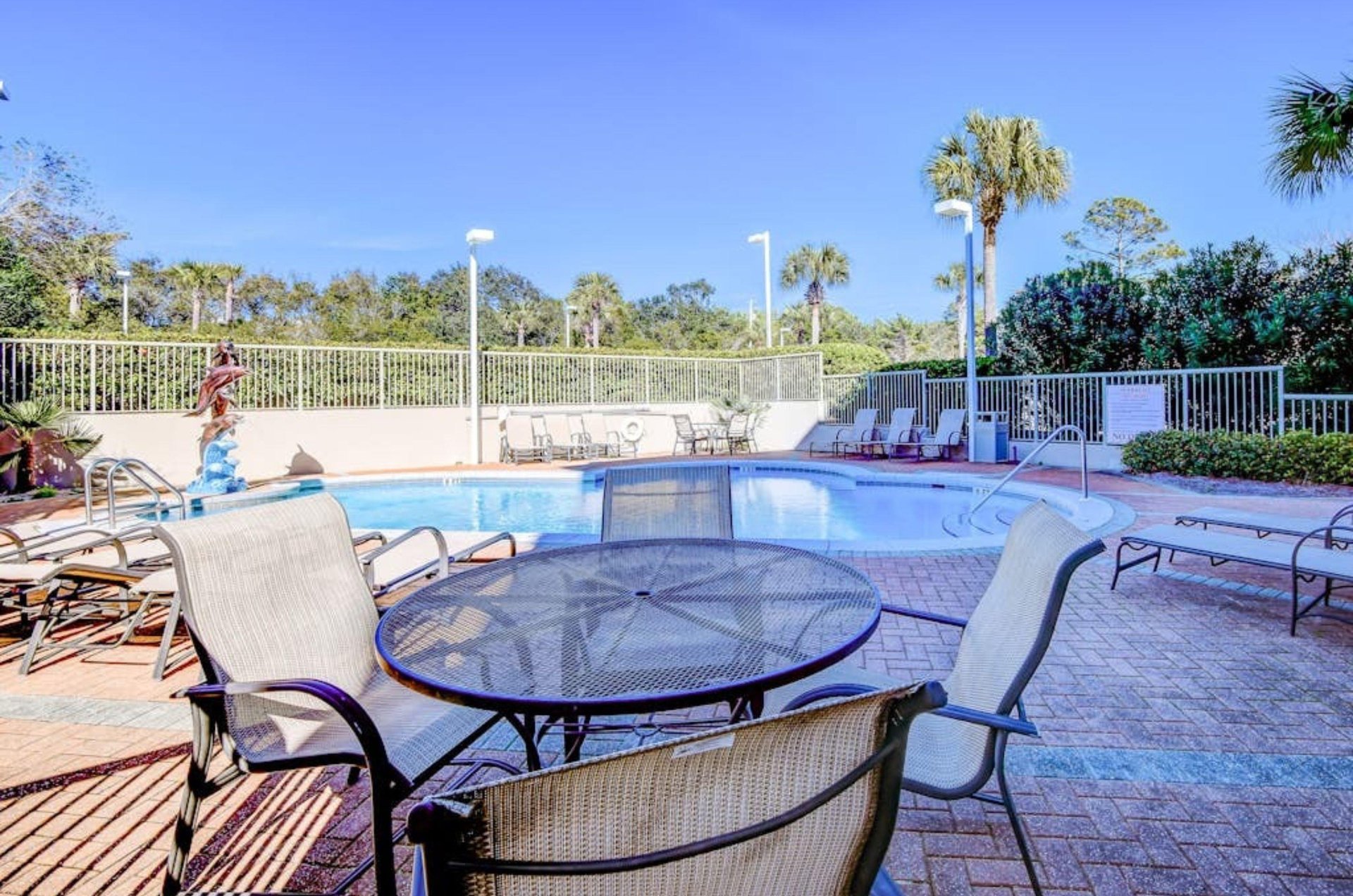 A chair and tables next to the pool at Abacos in Santa Rosa Beach Florida