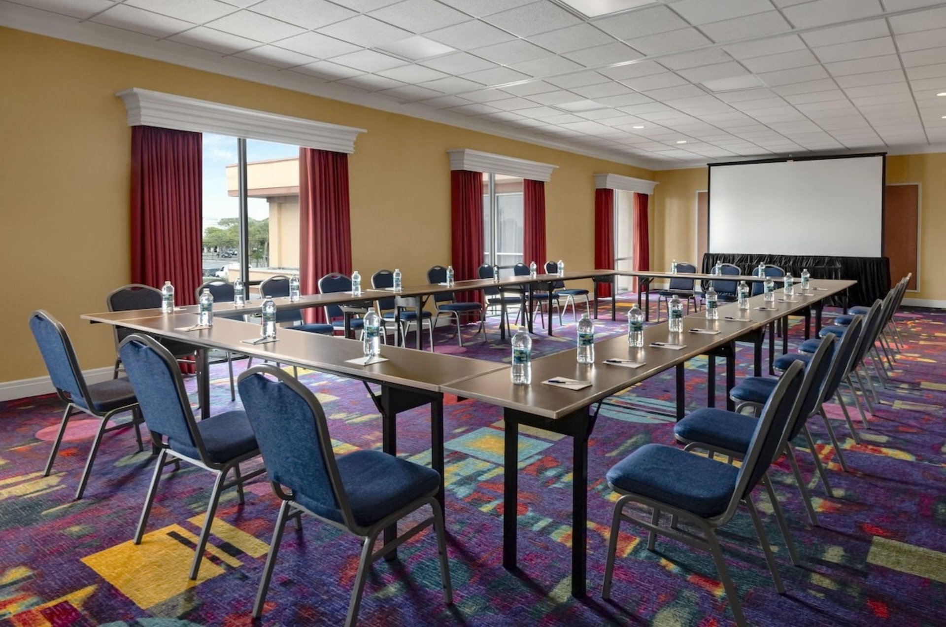 A large rectangular table with chairs in a conference room