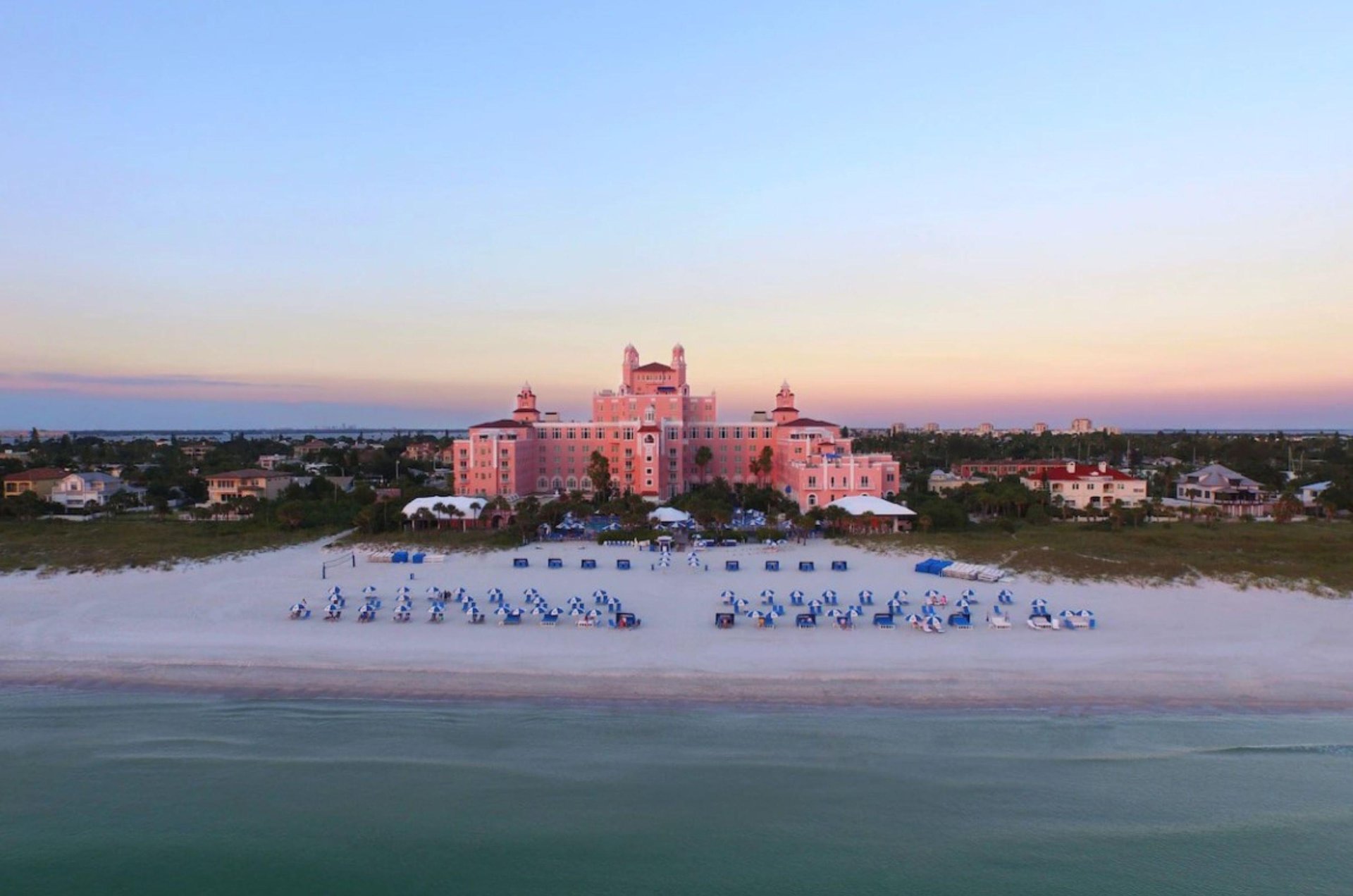 The Don Cesar is nestled beside a beautiful beach with lounge chairs and umbrellas ready for guests.