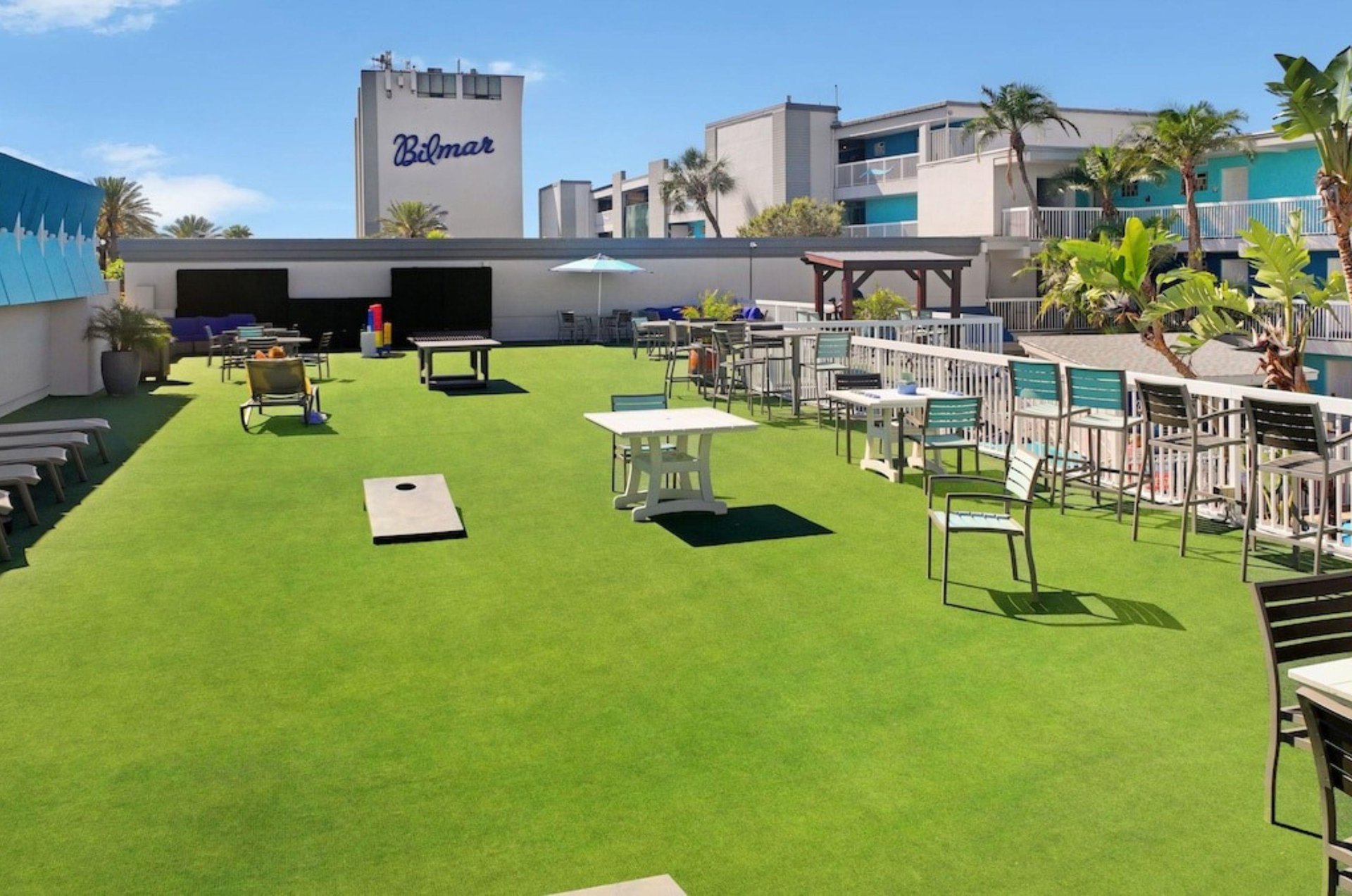 The rooftop sun deck with lounge chairs tables and yard games