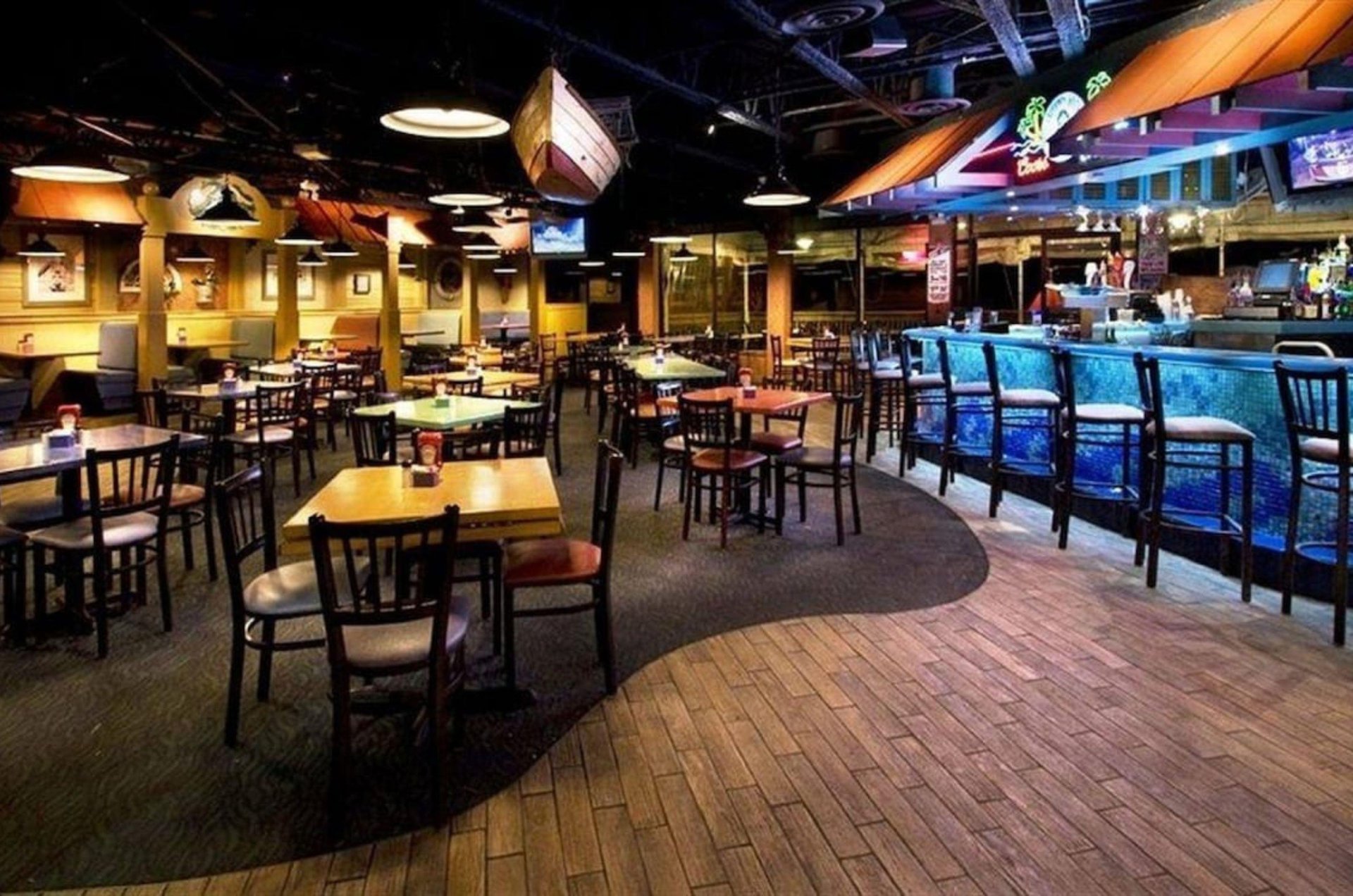 The interior of the resorts restaurant with numerous dining tables and a fully stocked bar