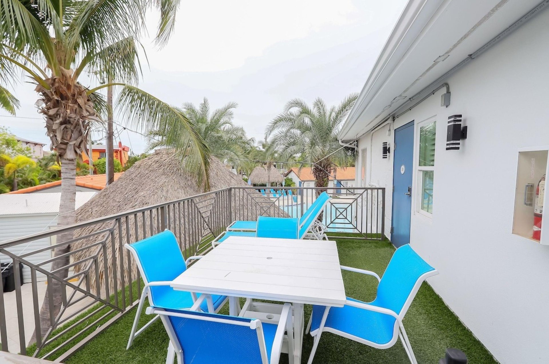An outdoor patio at Siesta Key Beach Resort and Suites with a table and lounge chairs