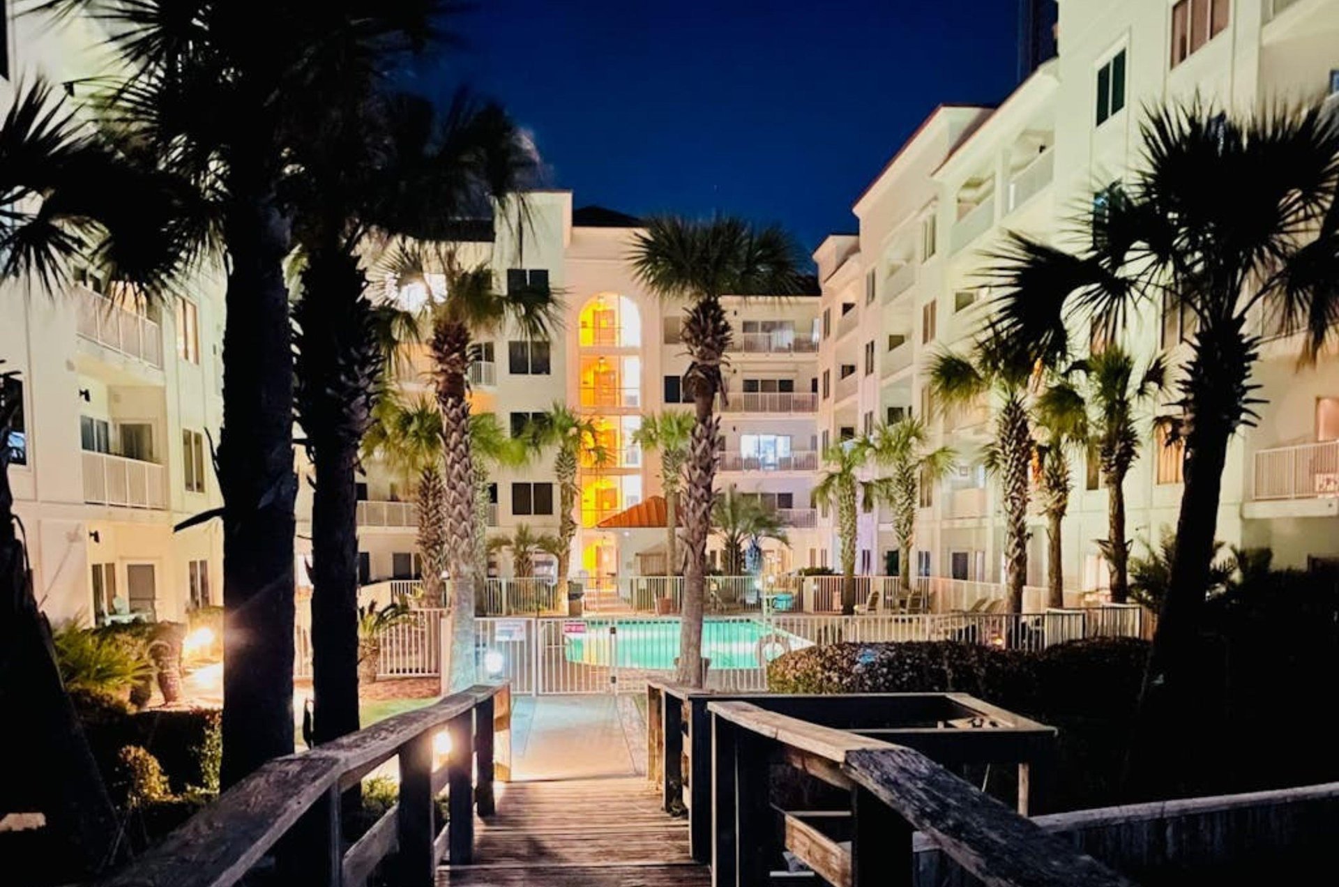View of the pool and condos at night at Palm Beach Condos in Orange Beach Alabama