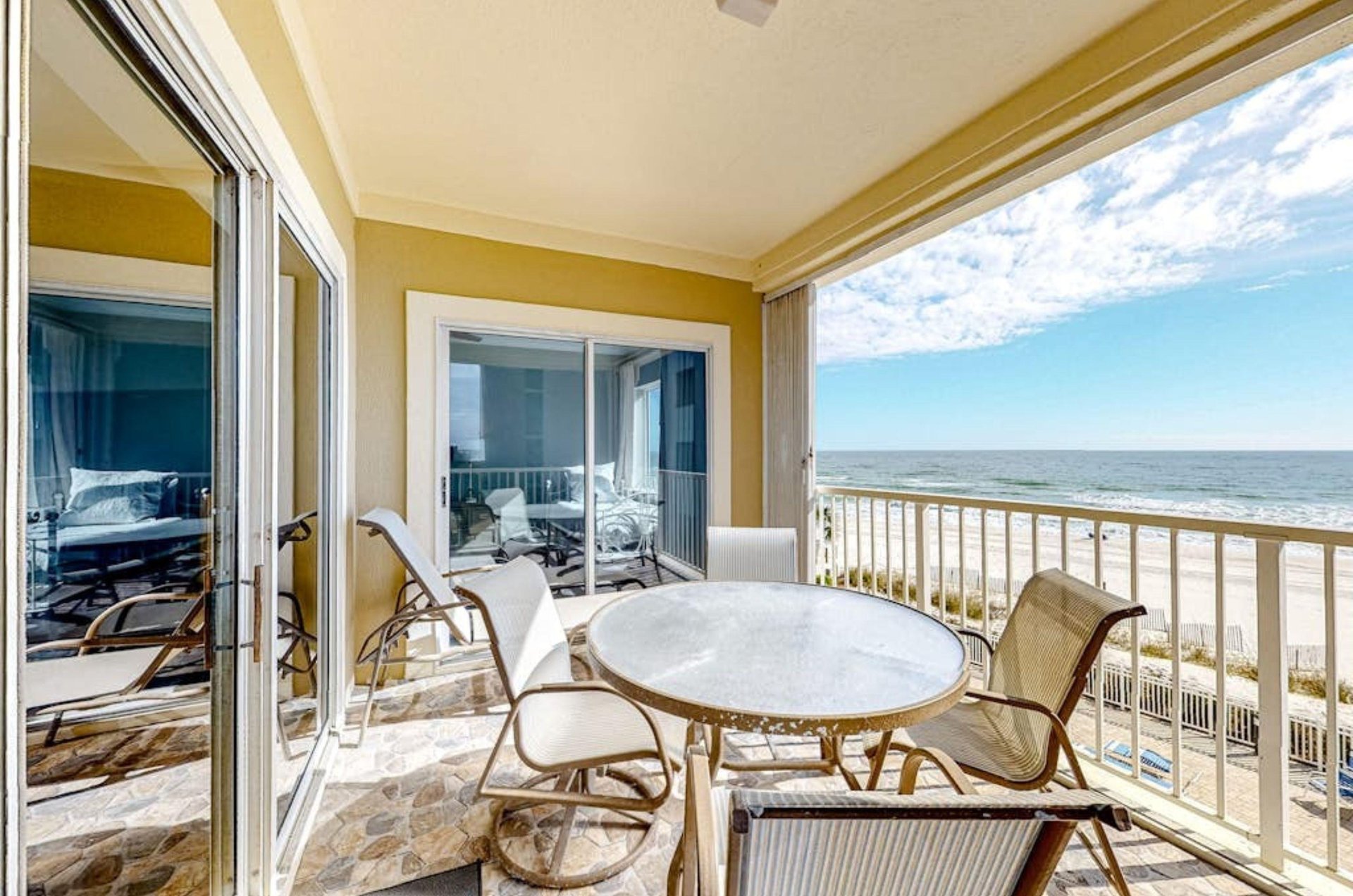 A balcony with chairs and tables overlooking the Gulf at Marlin Key