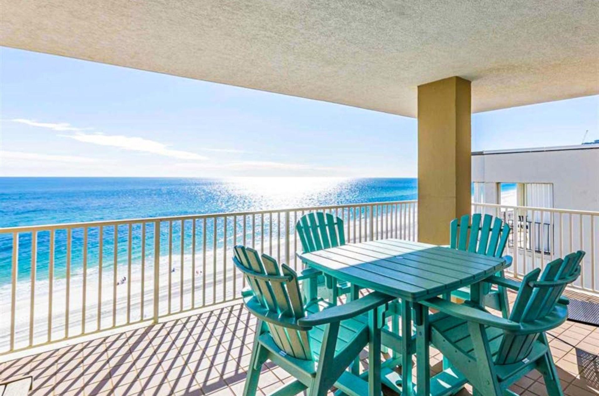 A table and chairs on a private balcony overlooking the beach at Romar Place in Orange Beach Alabama