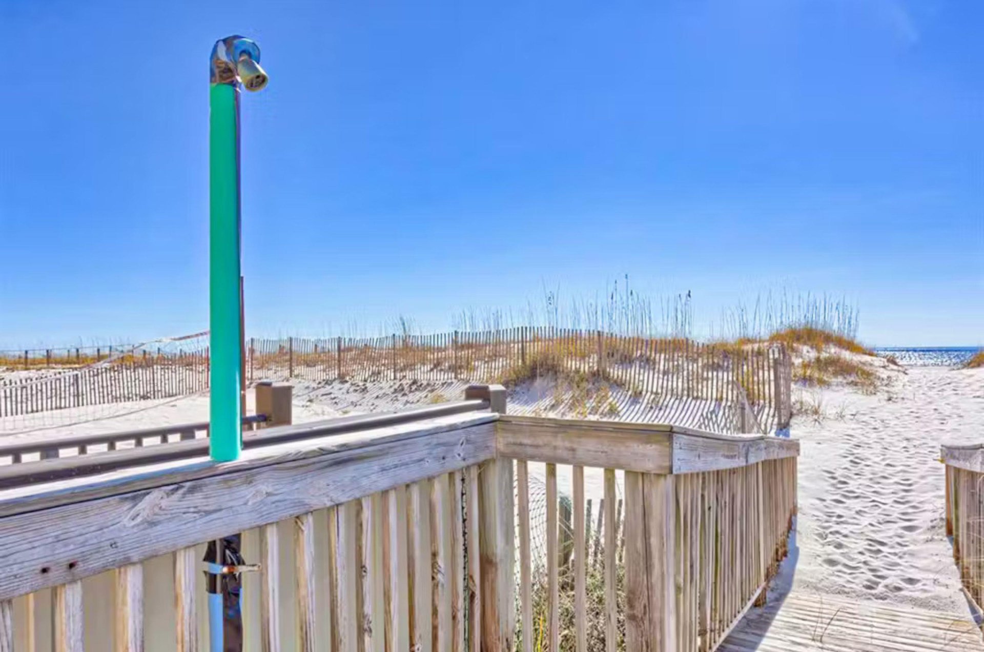 Boardwalk to the beach with an outdoor shower
