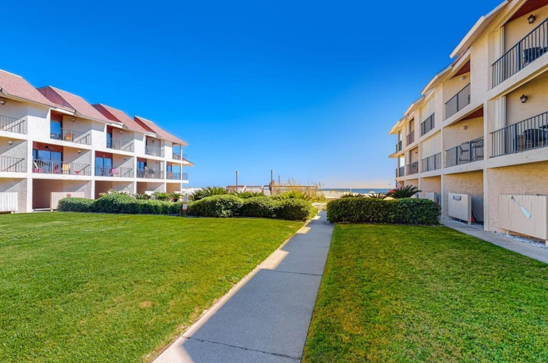 The courtyard between Gulfside Townhomes with a pathway leading to the beach