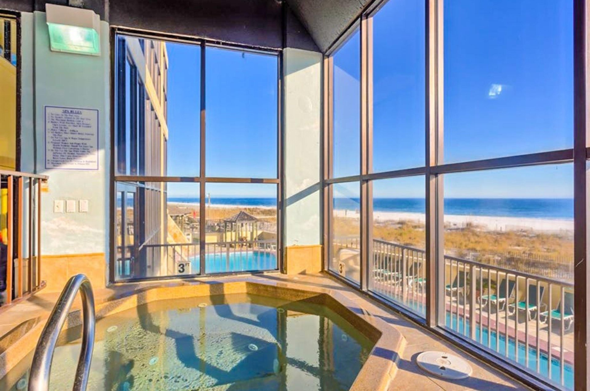 The indoor hot tub next to beachfront windows at Phoenix III in Orange Beach Alabama