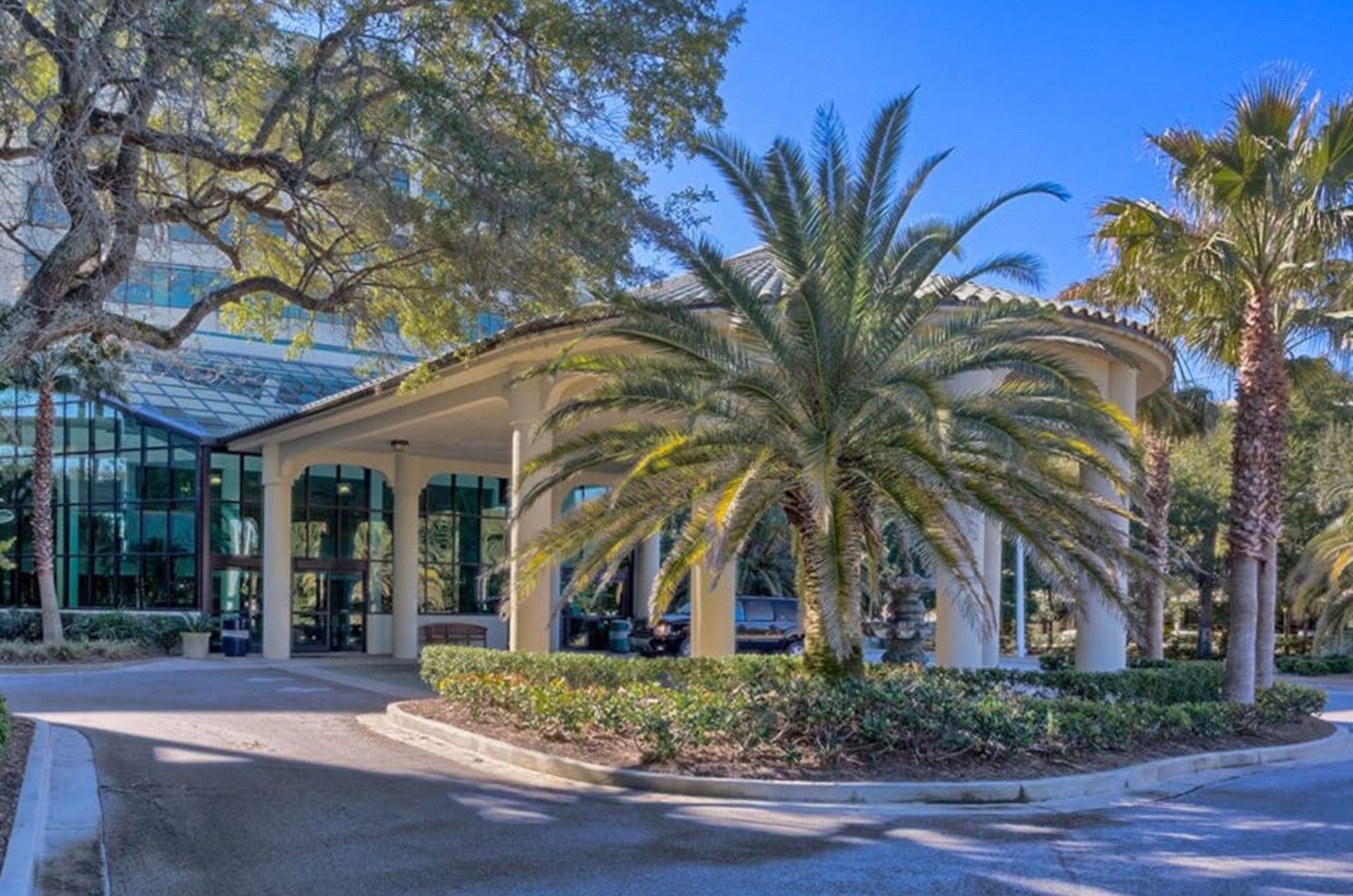 View of the entrance to Phoenix on the Bay with a covered drop off area and trees