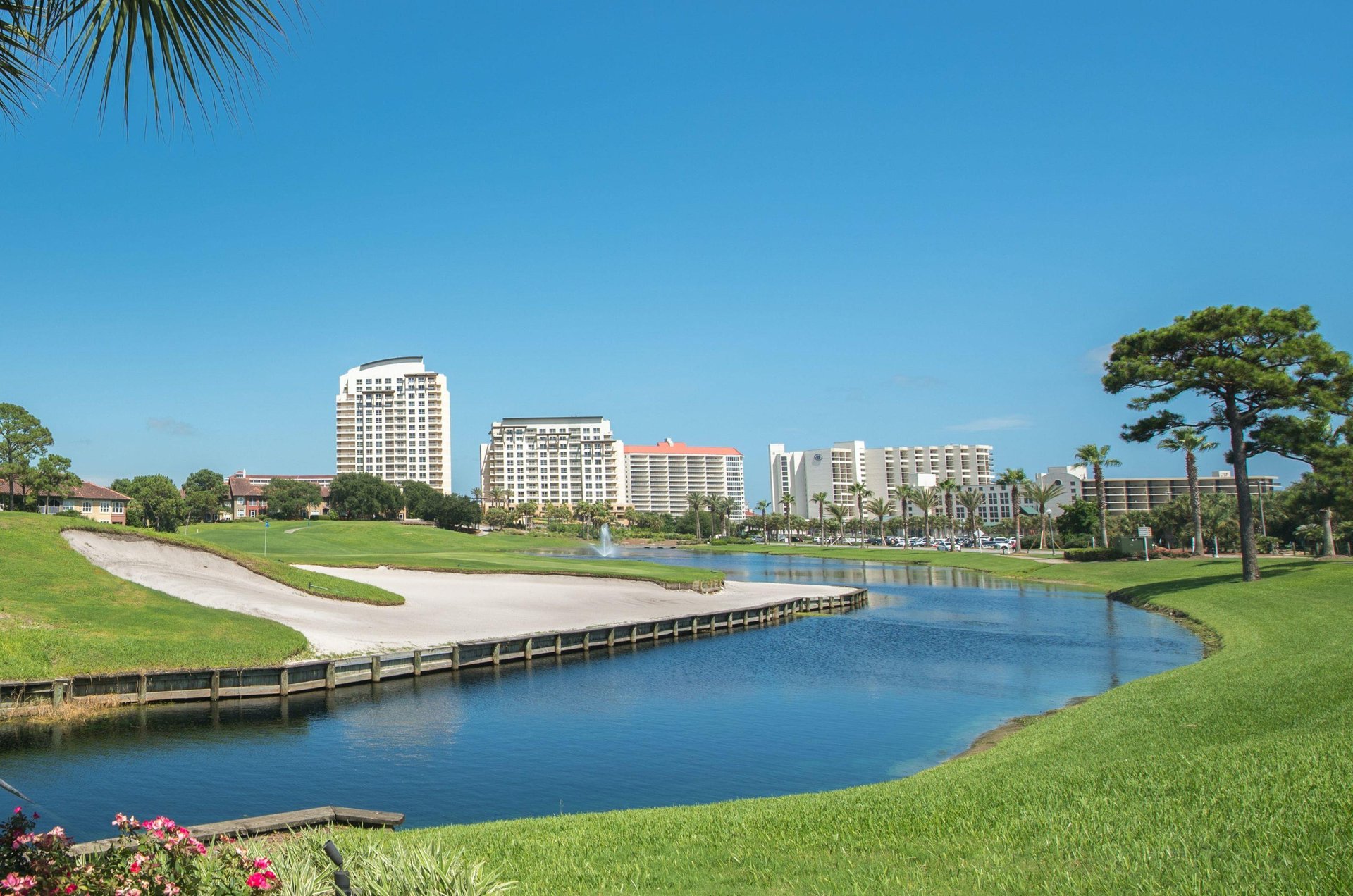 A picturesque view of one of the resorts golf greens next to a curving lake.