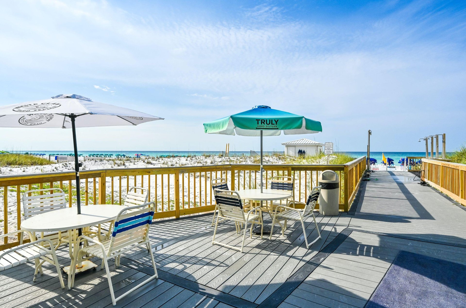 A beachside deck with tables and chairs for outdoor dining with a view