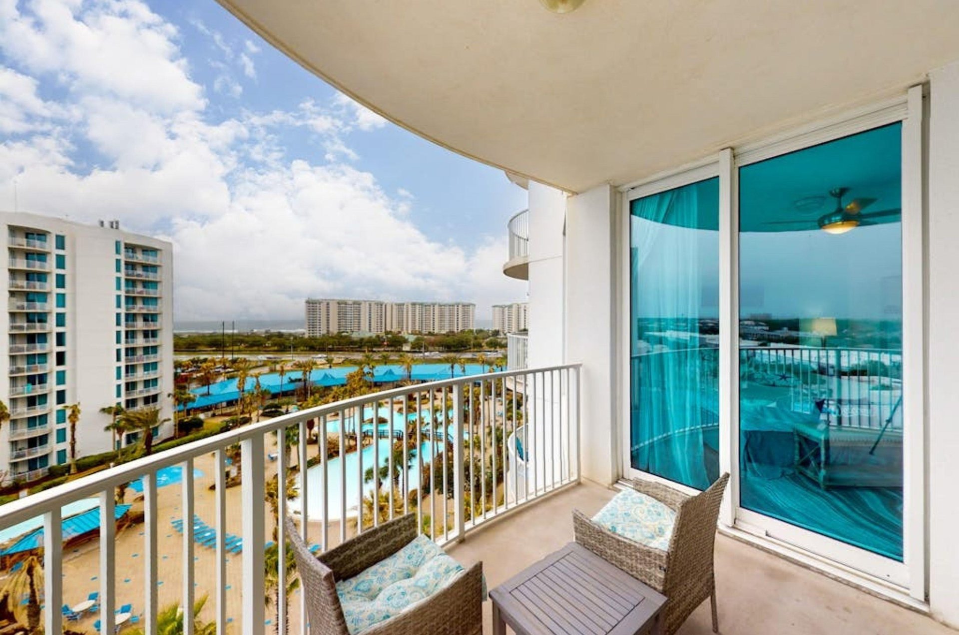 A private balcony with chairs overlooking the the pool area at the Palms of Destin in Destin Florida