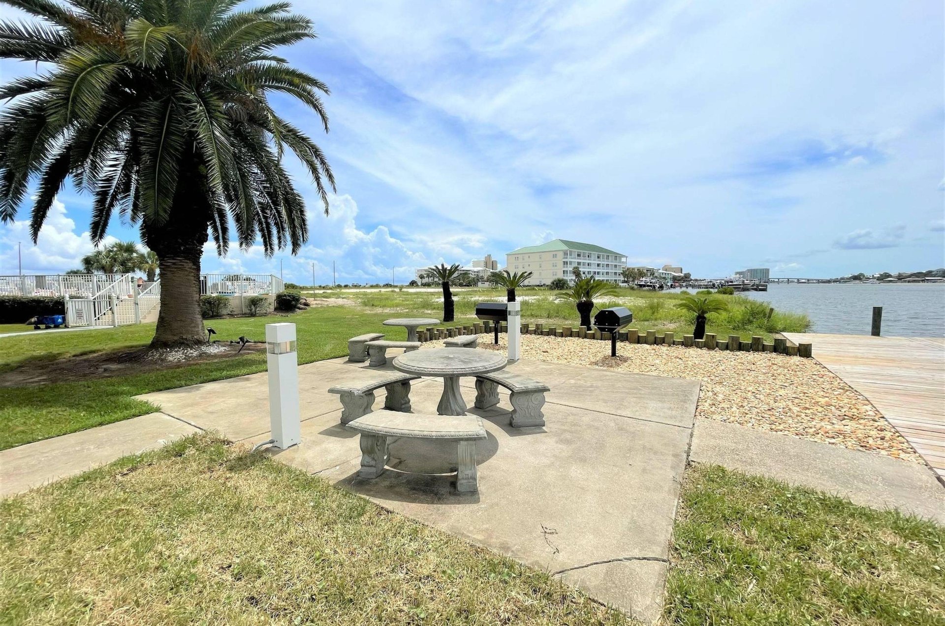 Barbecue grills and stone picnic tables next to the water at Jubilee Landing