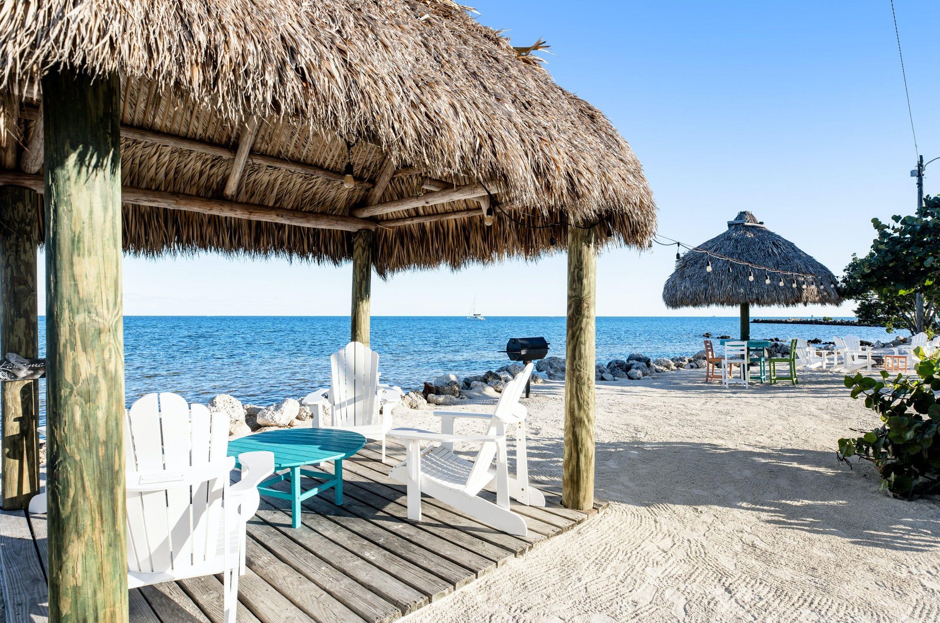 This waterfront hut is furnished with adirondack chairs around a coffee table and perfect for peaceful relaxation.