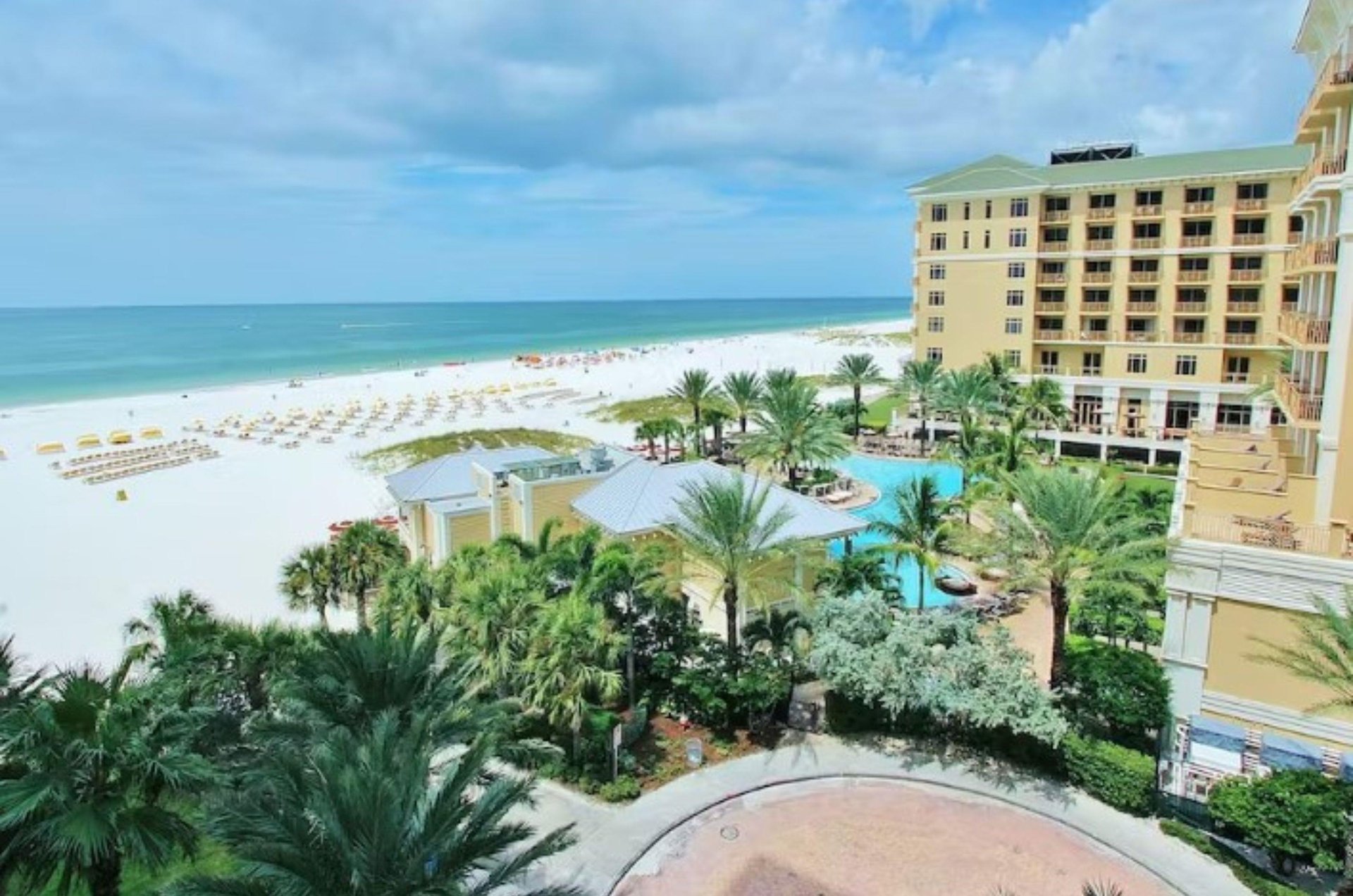 A Clearwater condo with its shimmering pool next to the wide beach and crystalclear Gulf of Mexico.