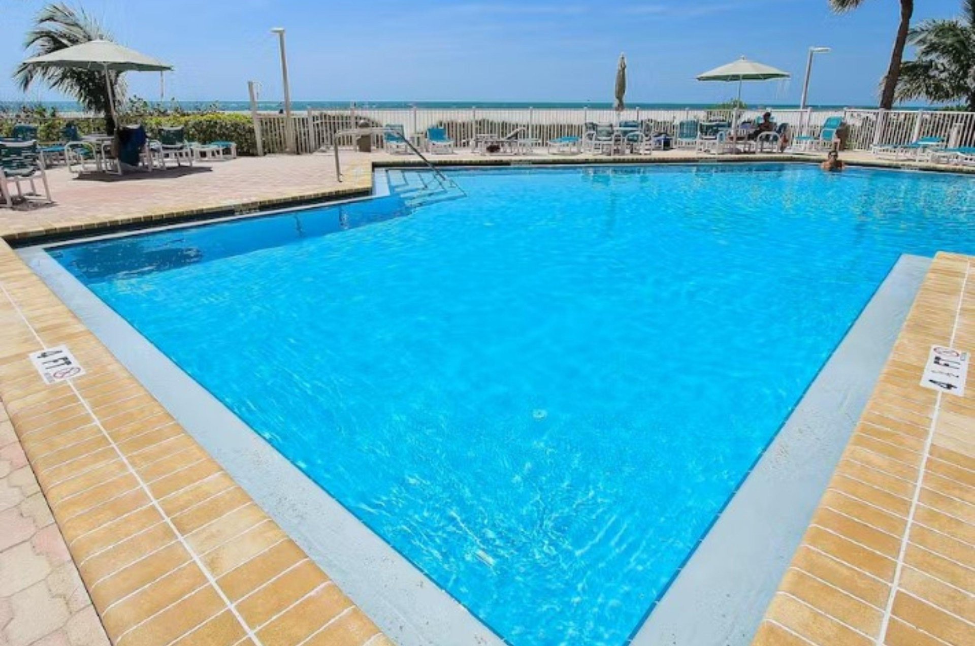 A Clearwater Beach condominium complexs beautiful glistening swimming pool next to the pristine coastline.