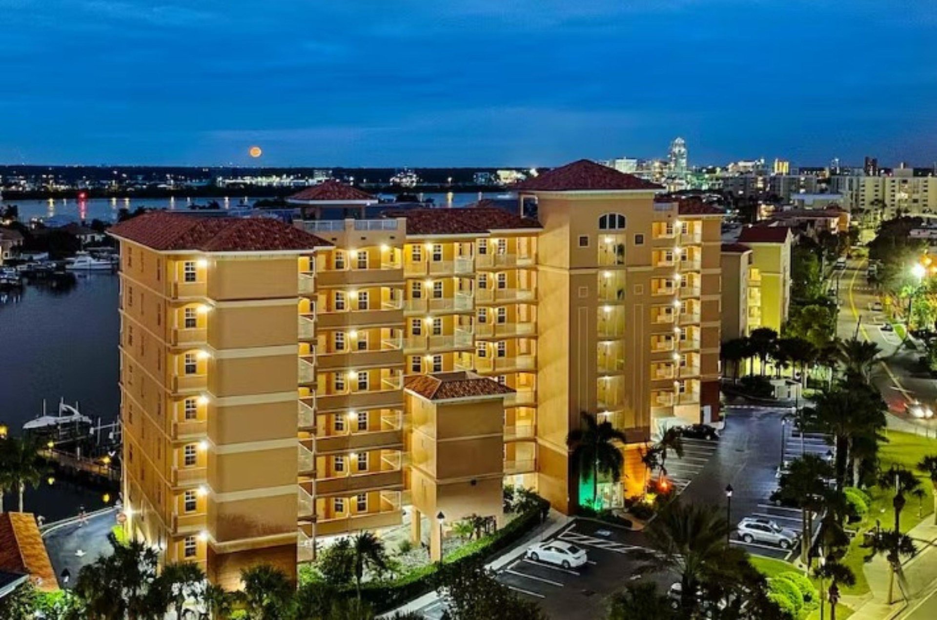 A waterfront Clearwater condo complex under a moonlit sky.
