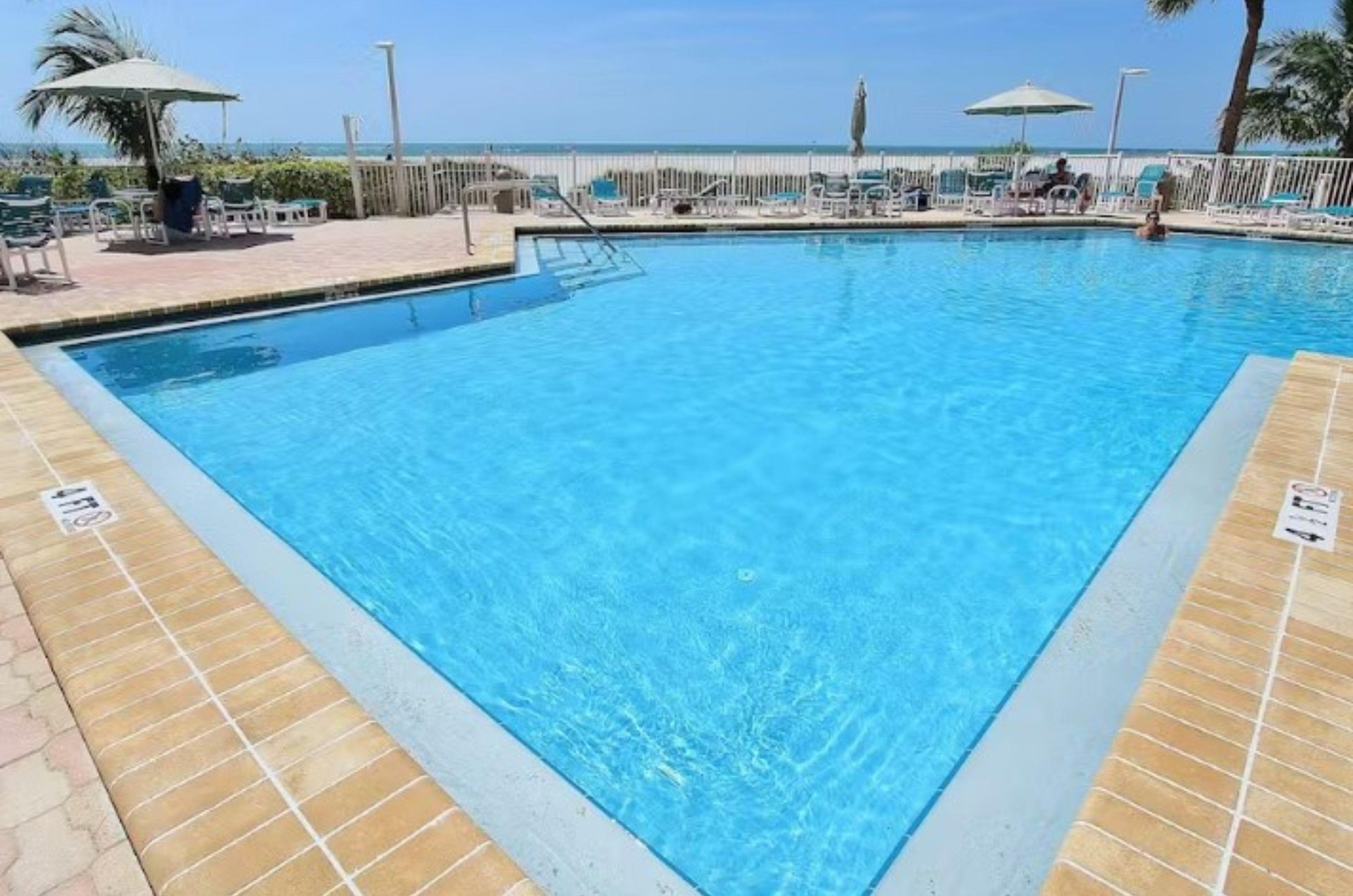 The shimmering angularshaped swimming pool and spacious sundeck sit next to the wide beach.