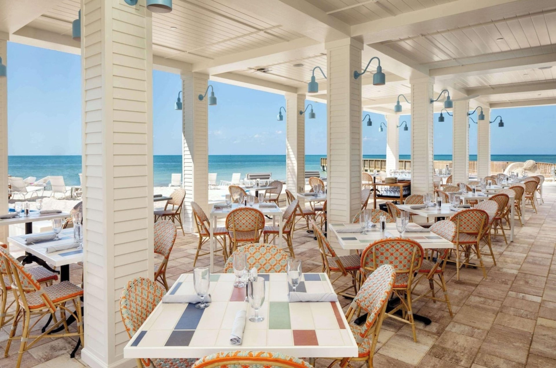 The beachfront patio with dining tables and chairs