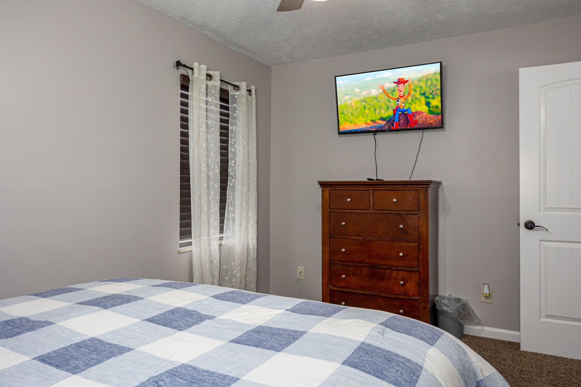 Bedroom with dresser and flat screen at Hoop Dreams Lodge
