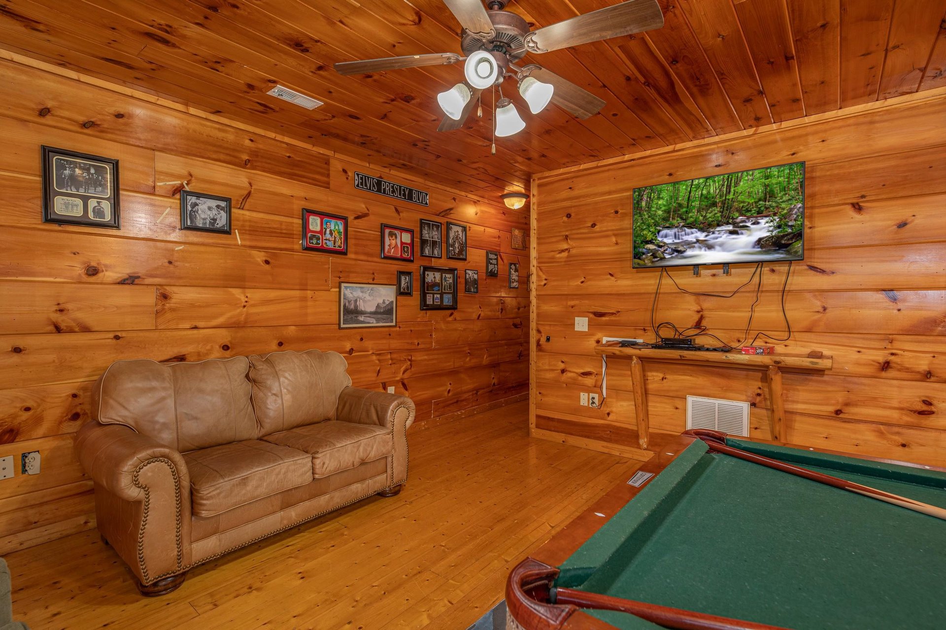 Loveseat, TV, and pool table in the game room at Firefly Ridge, a 2 bedroom cabin rental located in Pigeon Forge