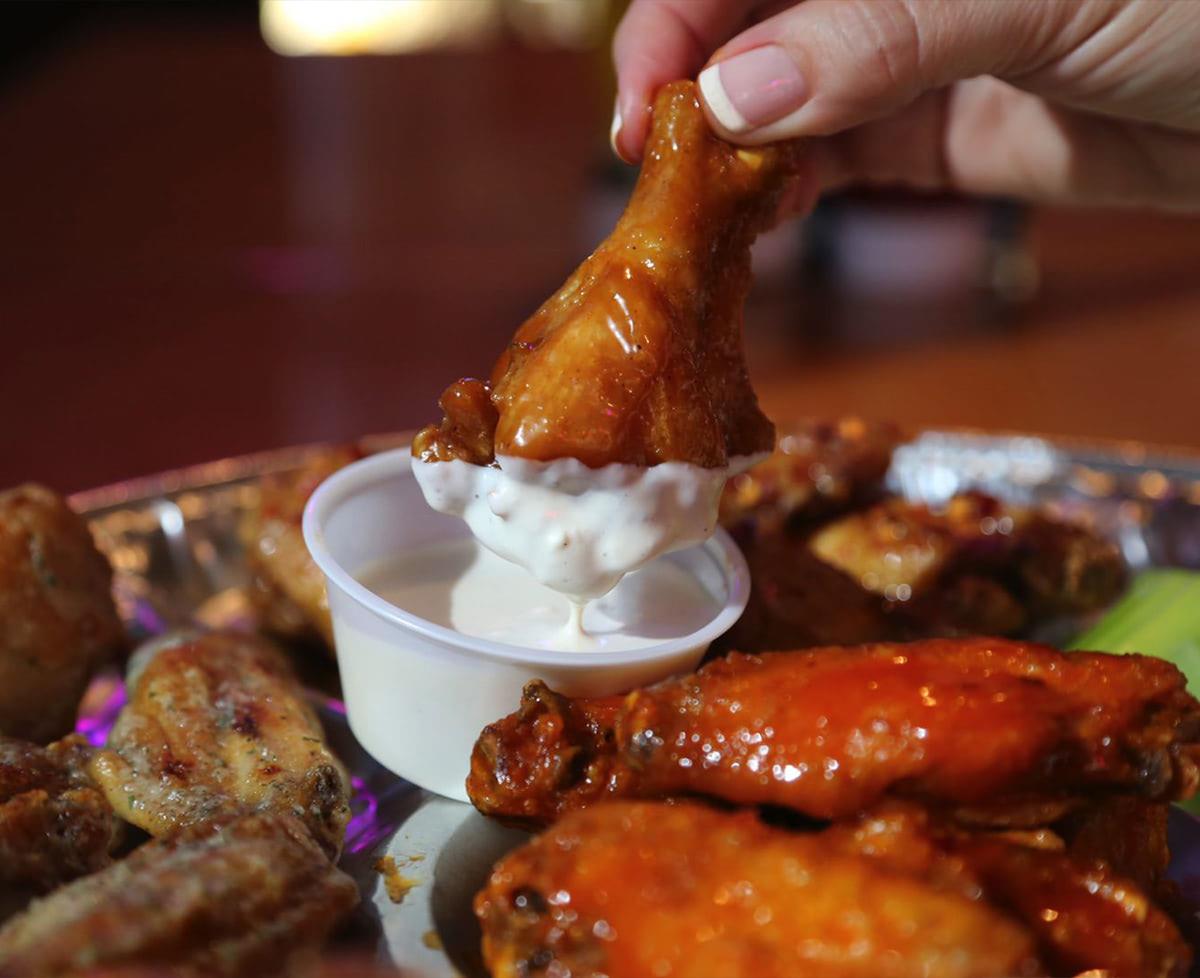 chicken wing dipped in sauce at blue moose burger and wings in pigeon forge