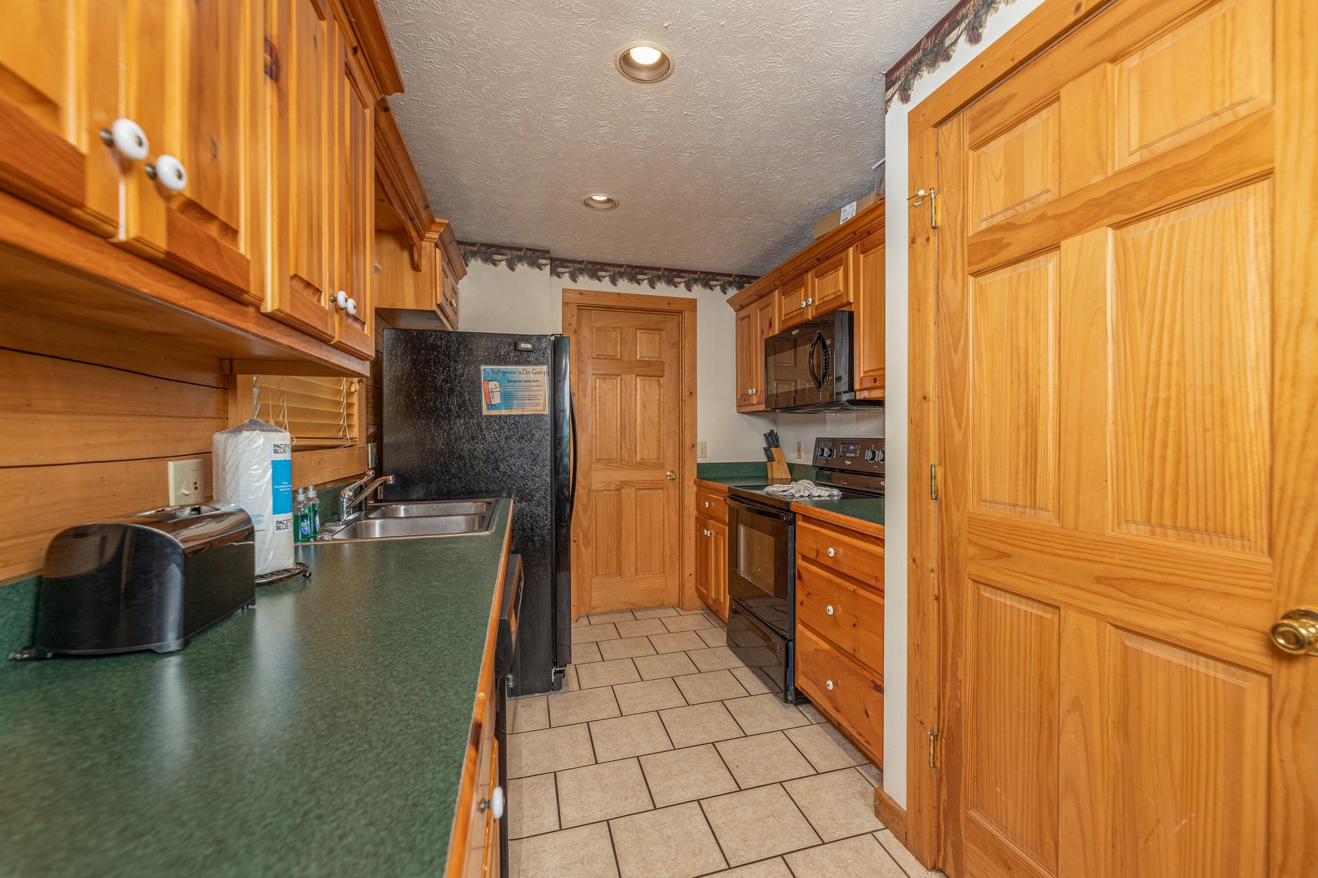 Galley kitchen with black appliances at Cubs Crossing, a 3 bedroom cabin rental located in Gatlinburg