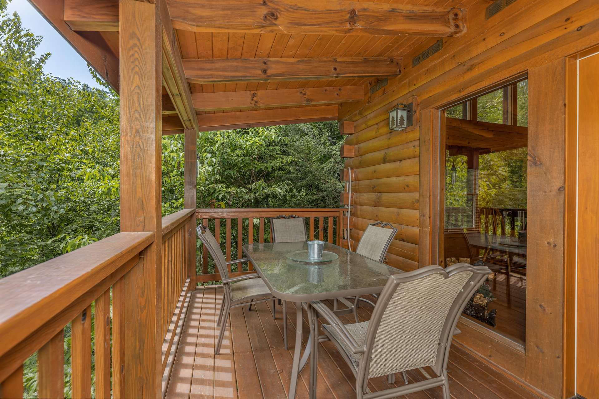 Outdoor dining for four on a covered deck at Cubs Crossing, a 3 bedroom cabin rental located in Gatlinburg