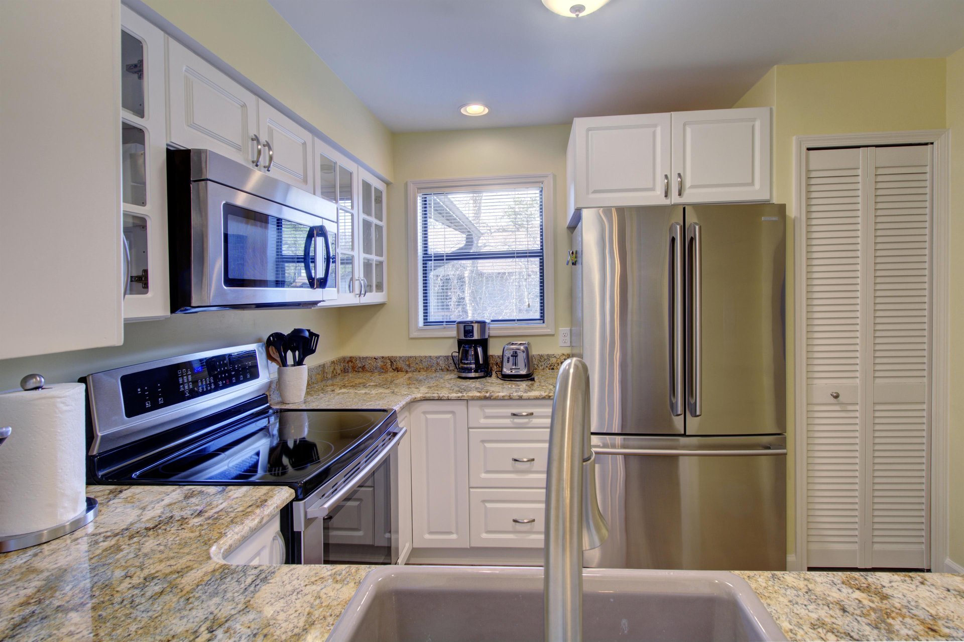 Cook with ease in this wellstocked kitchen at 406 Harbour Oaks, featuring granite countertops, stainless steel appliances, and everything you need for island meals in.